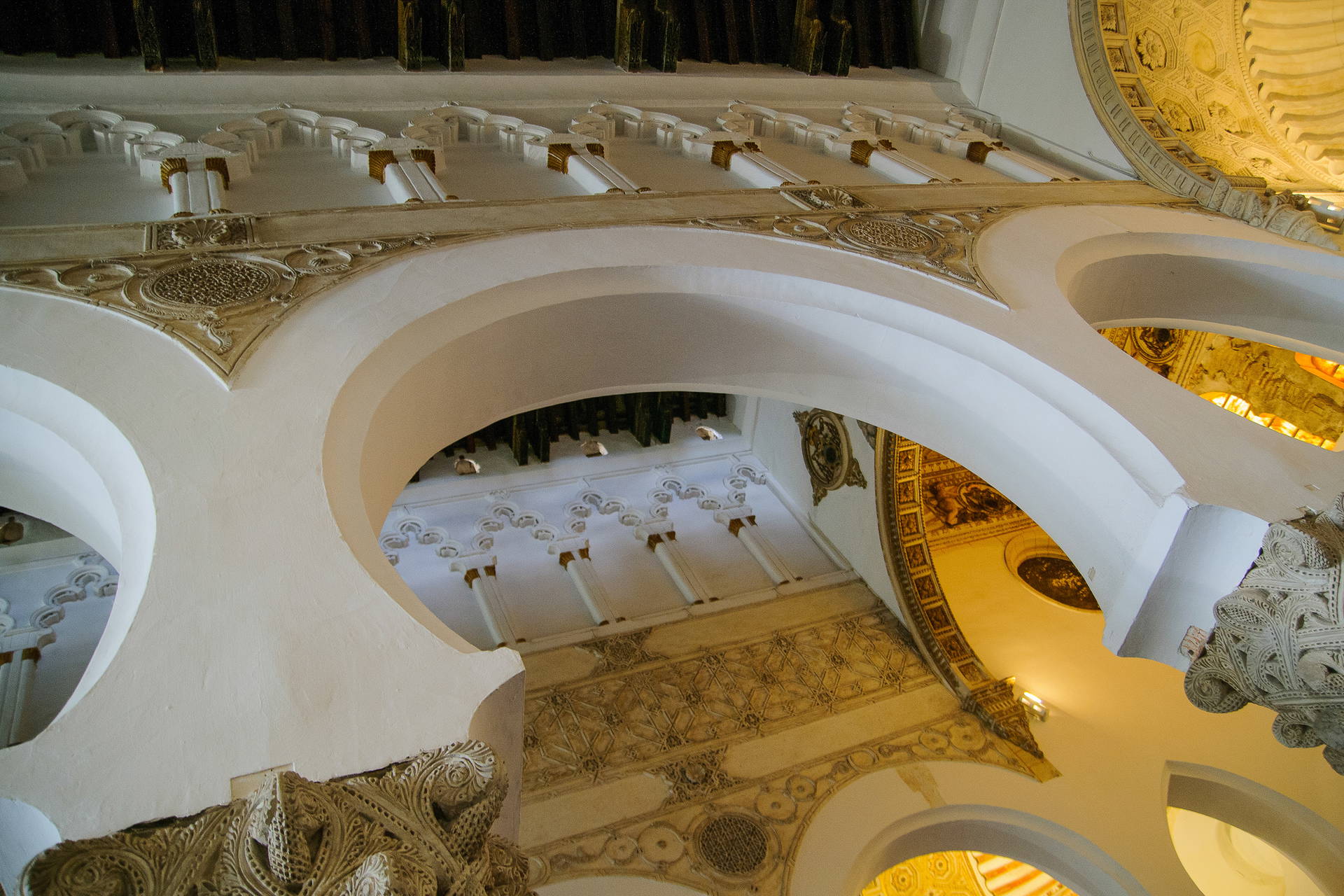 Wnętrze synagogi El Transito w Toledo z widocznymi łukami i dekoracjami.