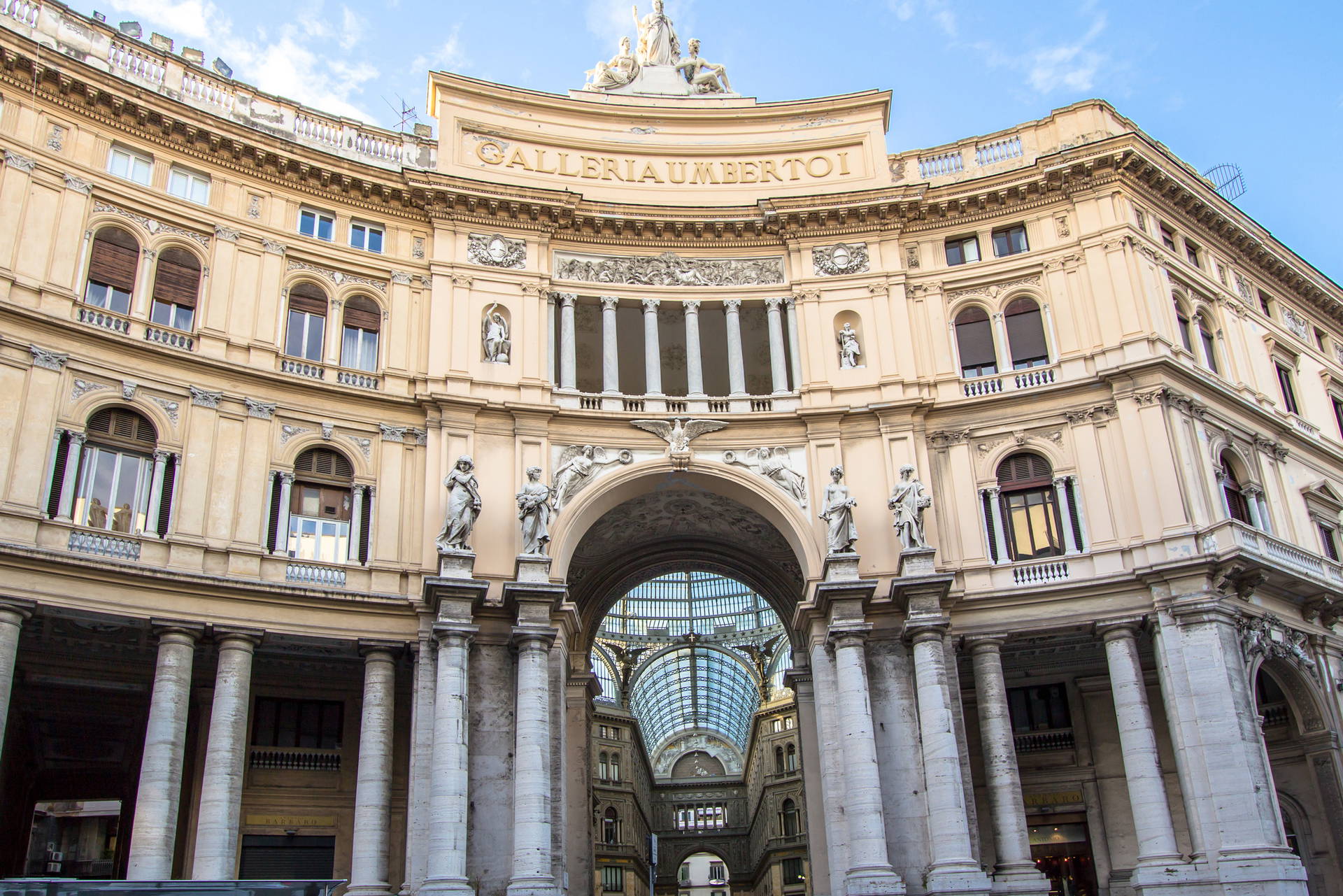 Galleria Umberto I w Neapolu, budowla z kolumnami i rzeźbami.