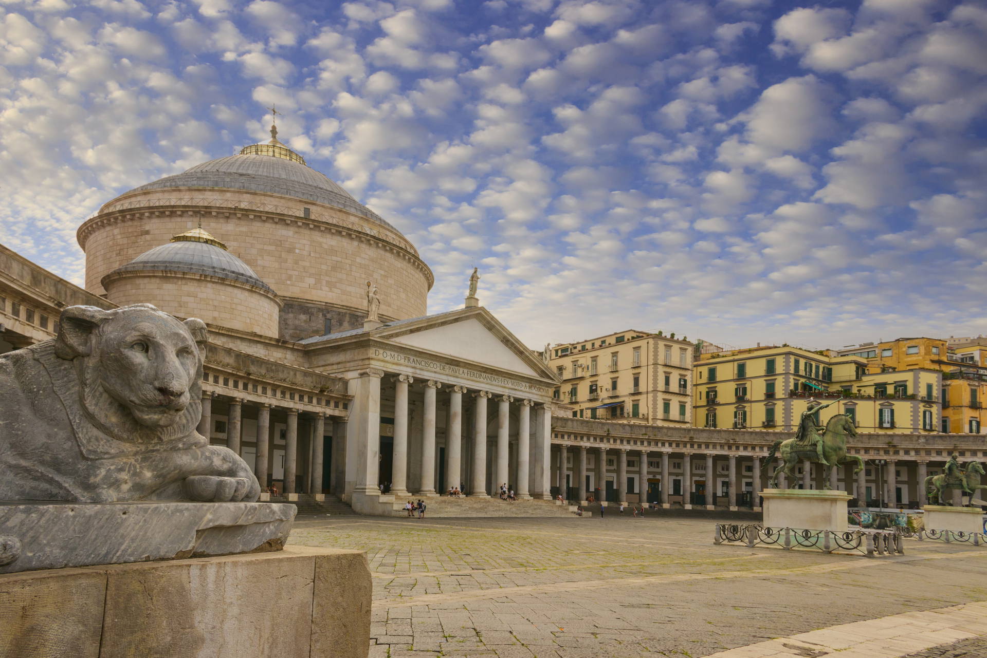 Piazza del Plebiscito w Neapolu z bazyliką i rzeźbą lwa.