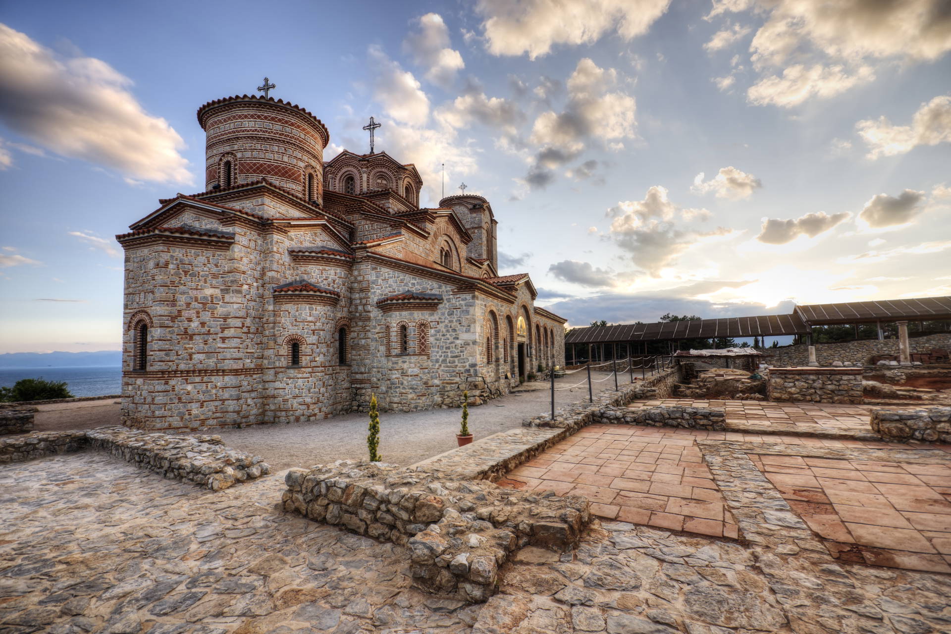 Cerkiew św. Jana Teologa w Kaneo, Macedonia. Kamienny kościół z kopułami zwieńczonymi krzyżami.