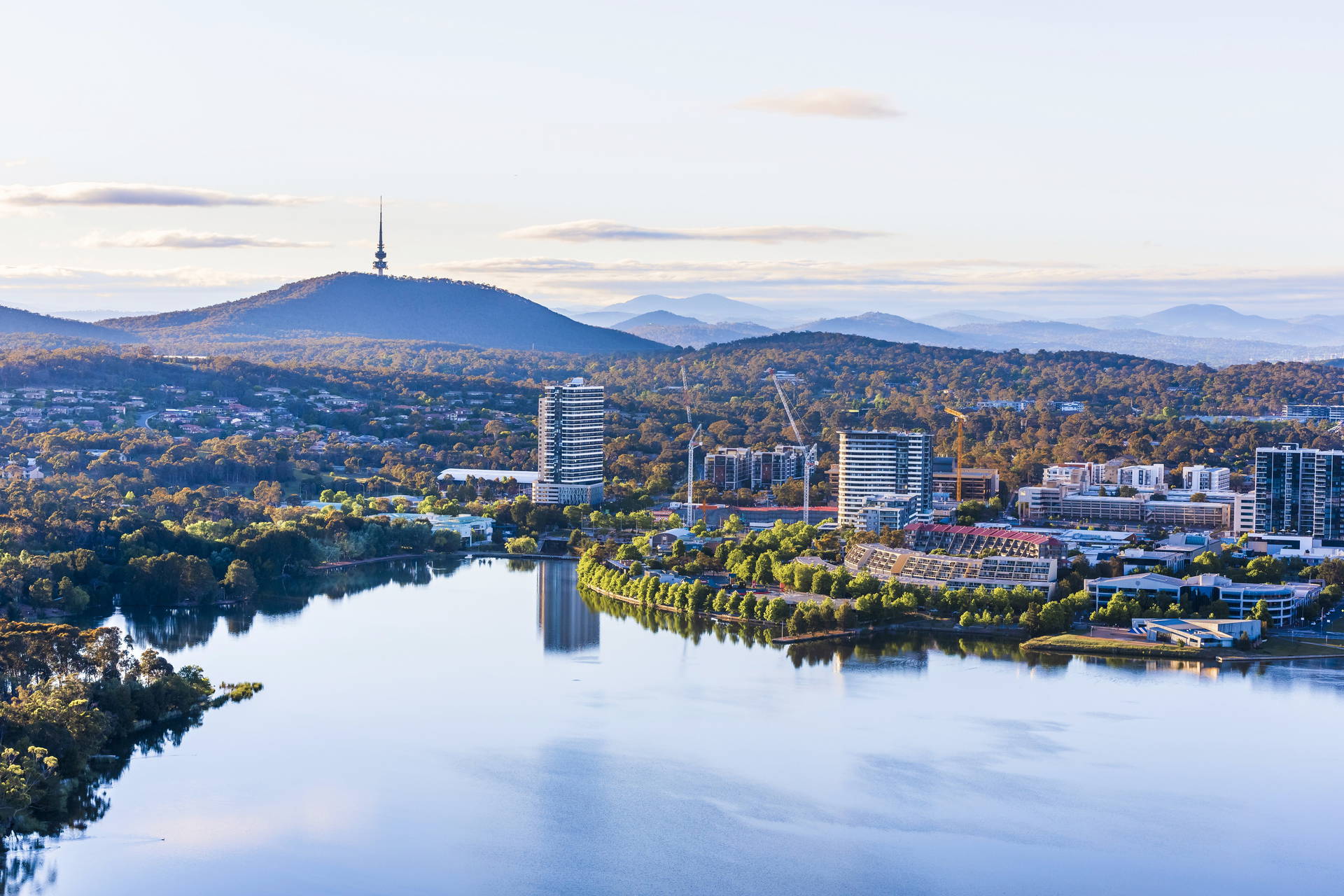 Panorama Canberry z jeziorem Burley Griffin, wieżą Black Mountain i zabudowaniami miejskimi.