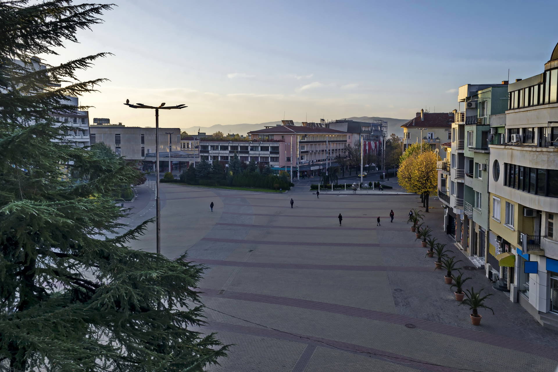 Panoramiczny widok na plac miejski z budynkami w tle.
