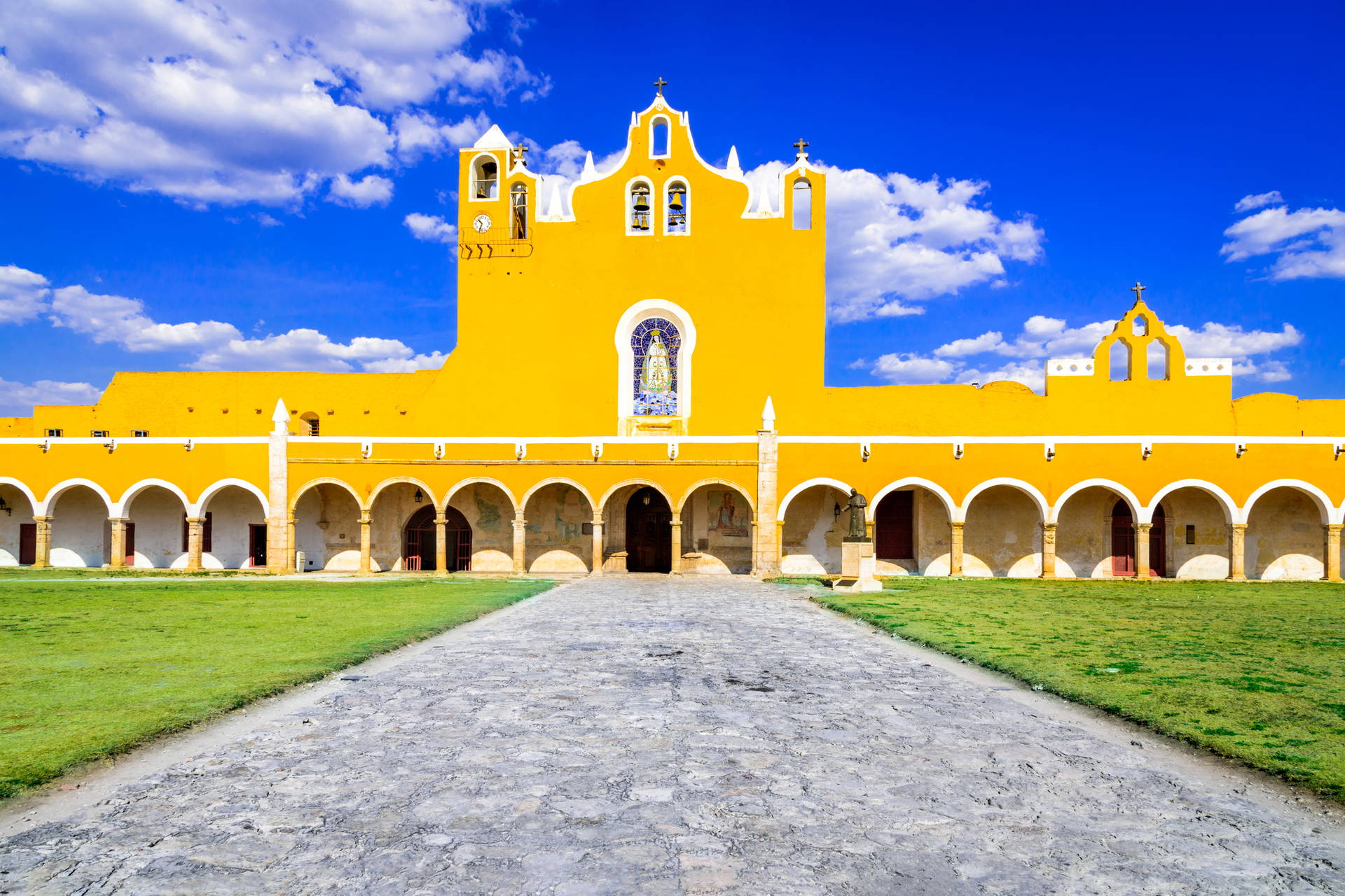 Żółty budynek z łukami i wieżami w Izamal, Meksyk.