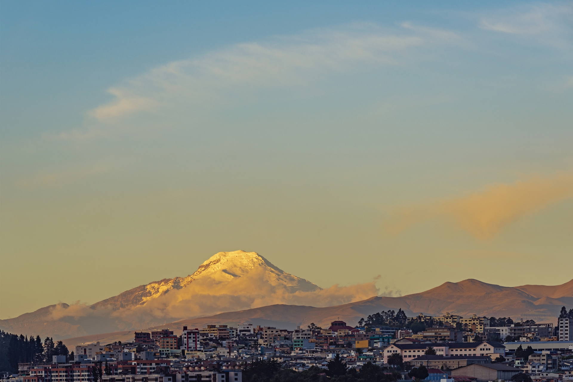 Miasto z ośnieżonym wulkanem Chimborazo w tle.