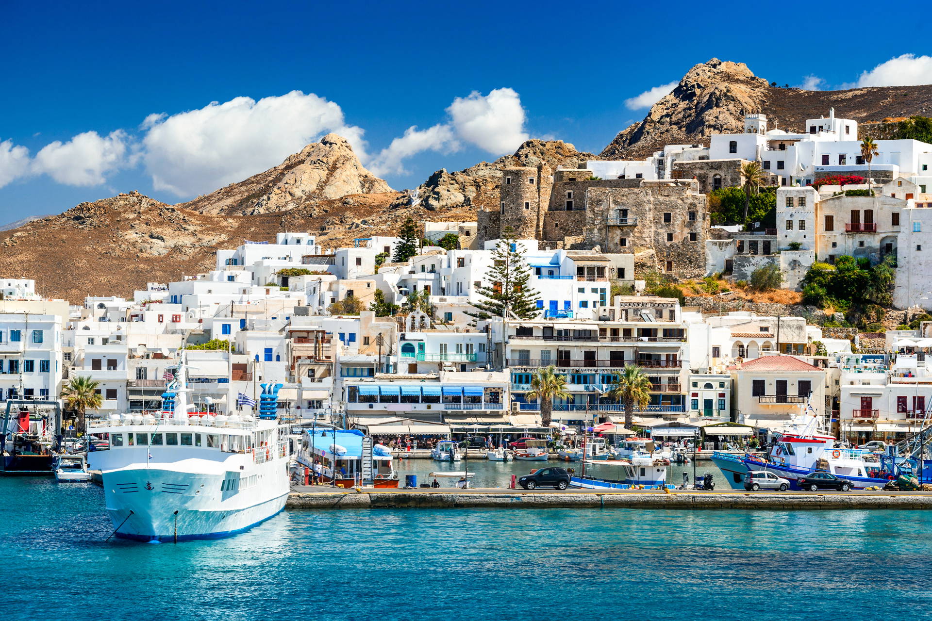 Widok na port i białe budynki w miejscowości Chora na greckiej wyspie Astypalaia.