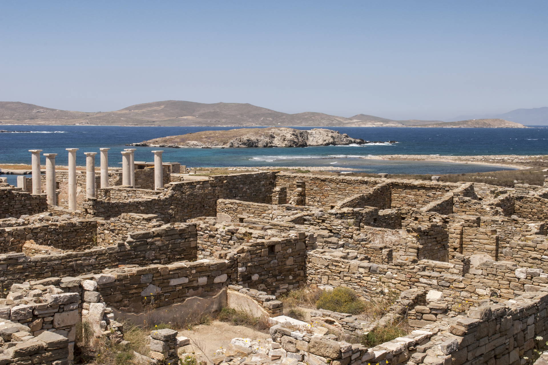 Delos, Grecja. Ruiny starożytnego miasta i kolumny na tle morza.