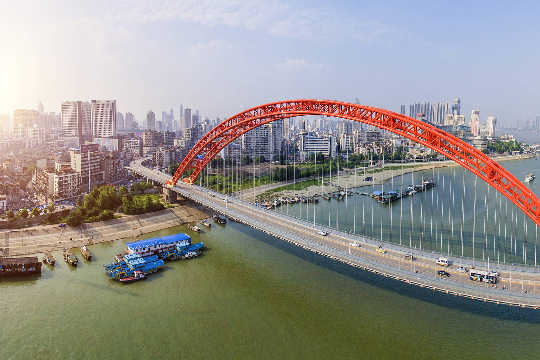 Panorama Wuhan z czerwonym, łukowym mostem nad rzeką Jangcy.