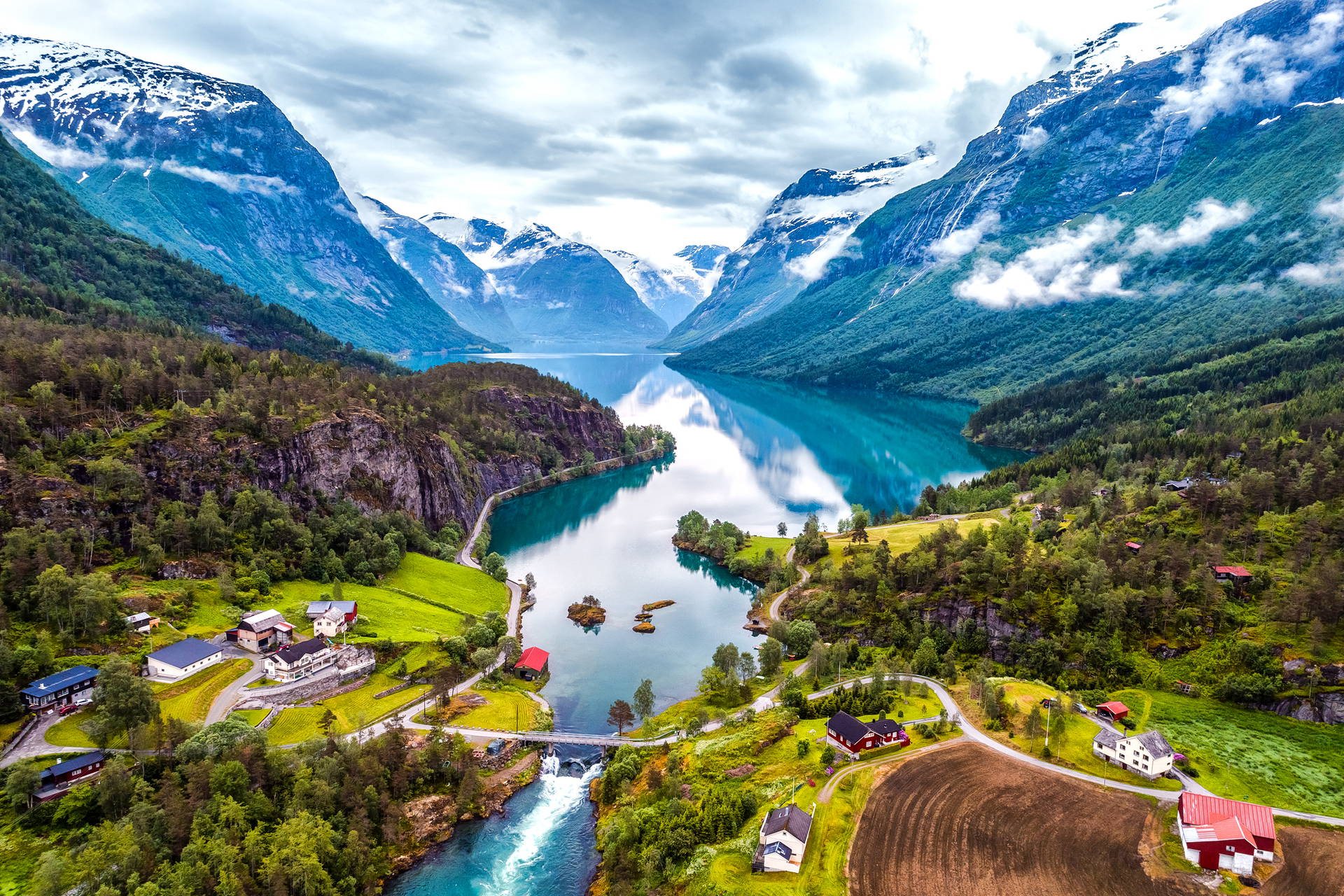 Krajobraz Norwegii z jeziorem, górami i domami.