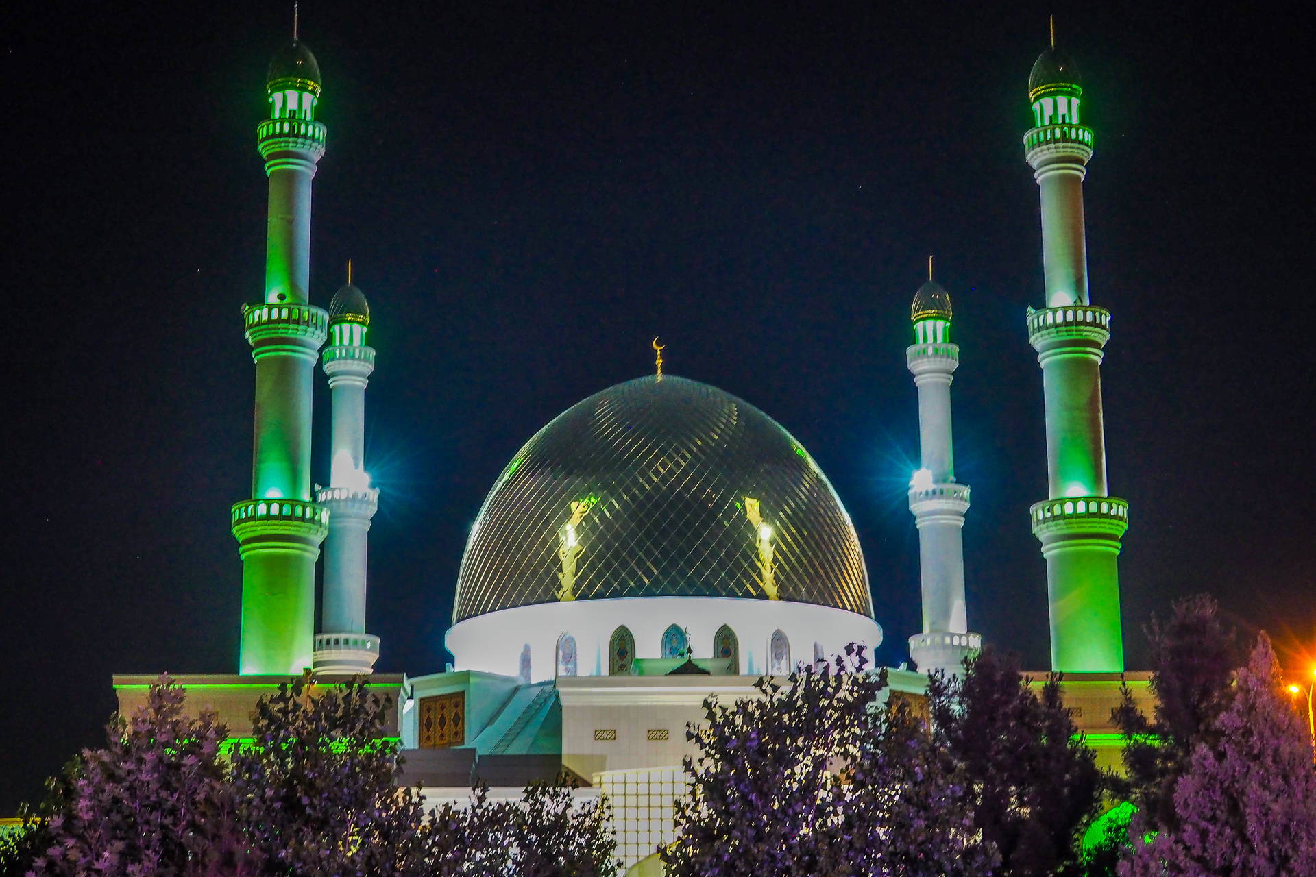 Meczet z kopułą i minaretami nocą.