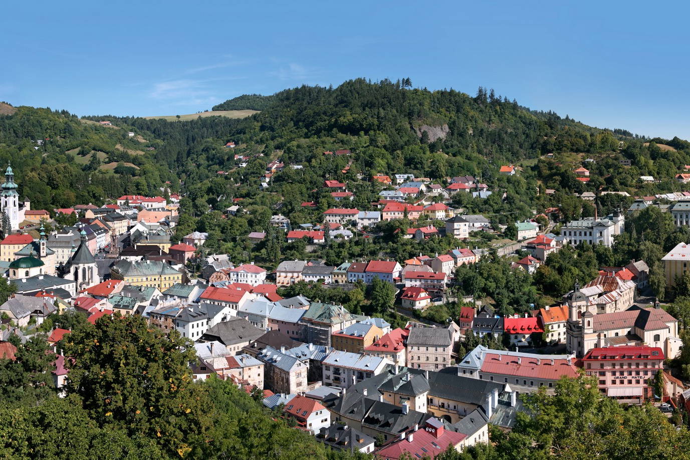 Panorama miasta Bańska Szczawnica na tle wzgórz.