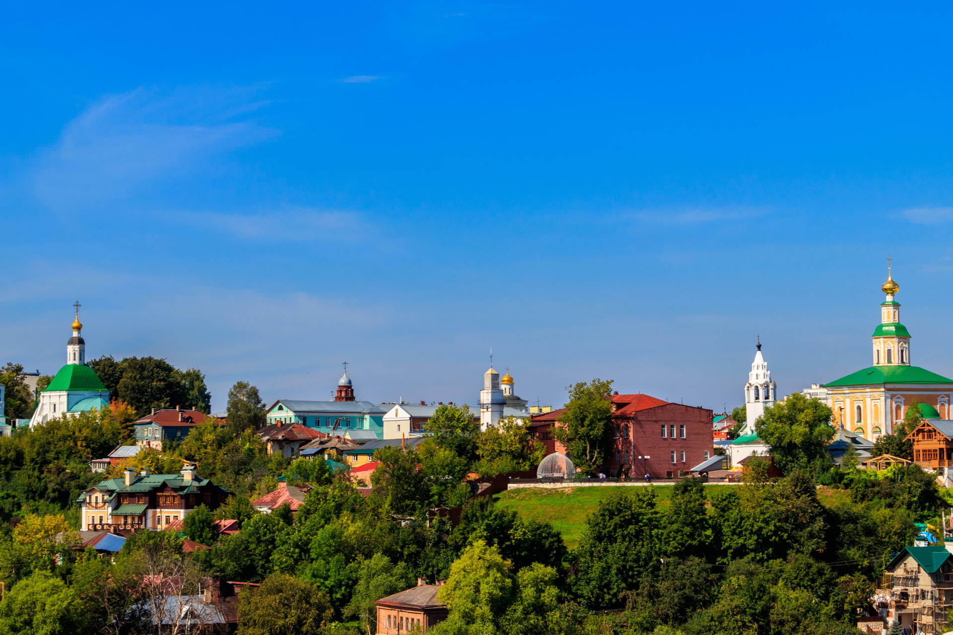 Panorama miasta z cerkwiami i budynkami otoczonymi zielenią.