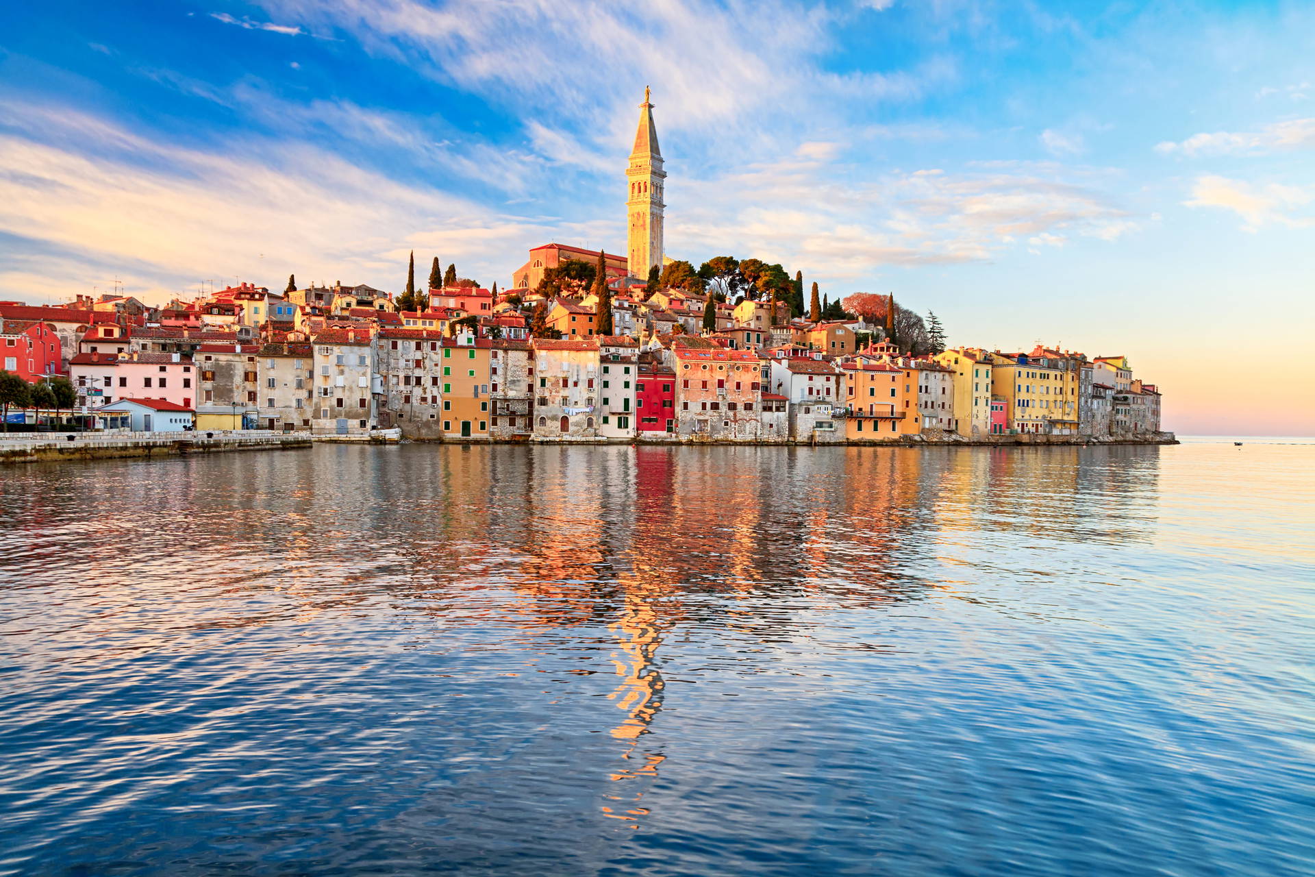 Panorama chorwackiego Rovinj z kościołem św. Eufemii odbijającym się w morzu.