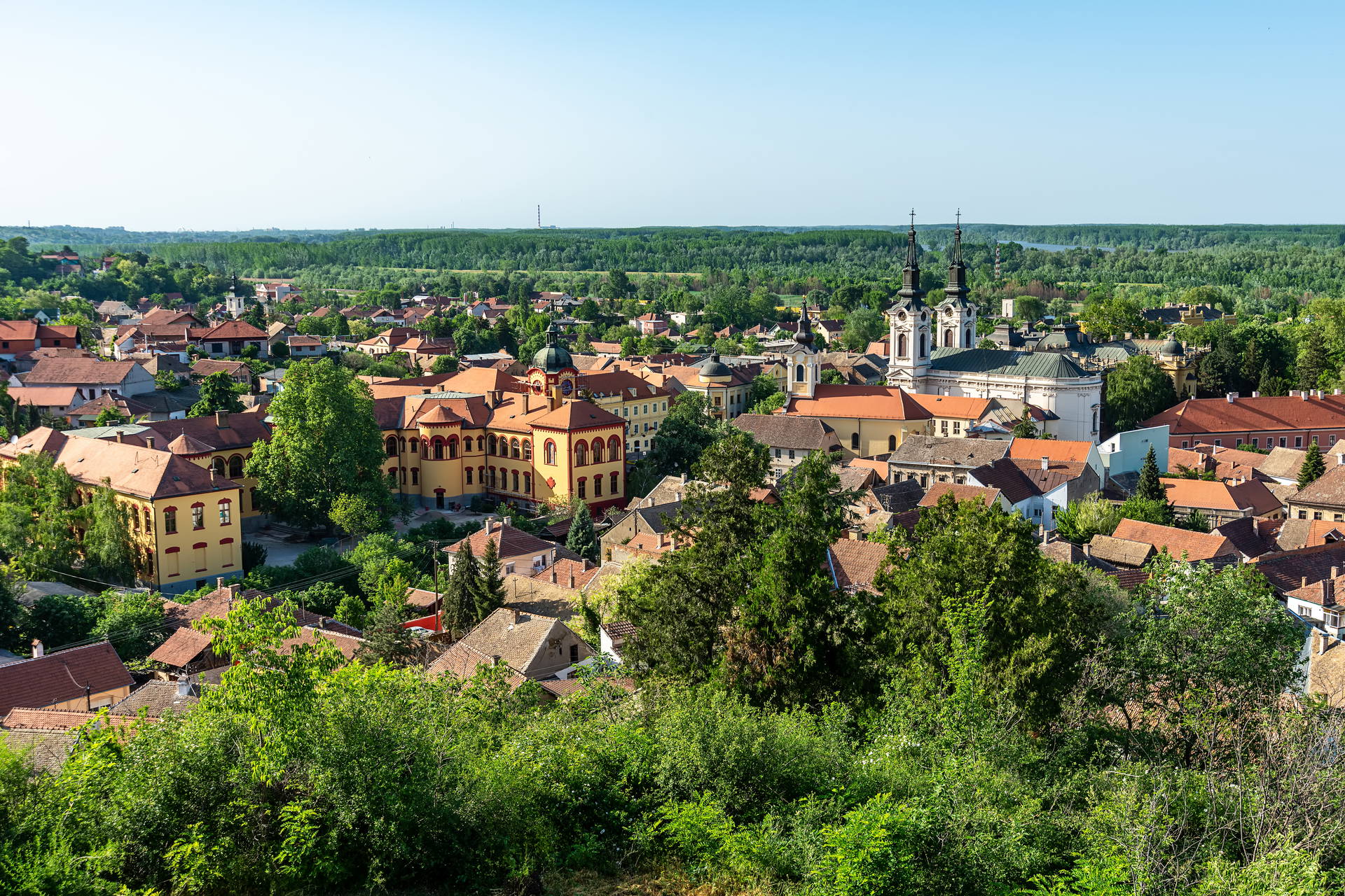 Panorama Sremskich Karlovców w Serbii. Miasteczko z czerwonymi dachami i cerkwią na tle Dunaju.