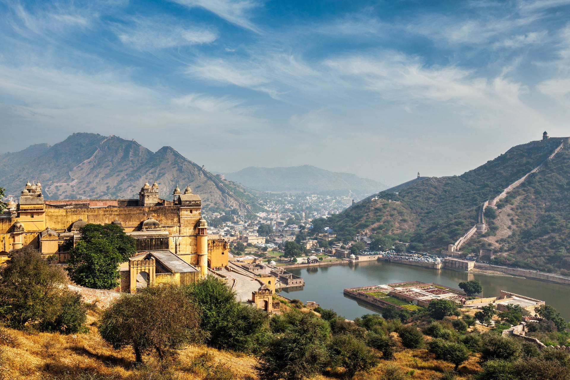 Amber Fort w Indiach, otoczony wzgórzami i jeziorem.