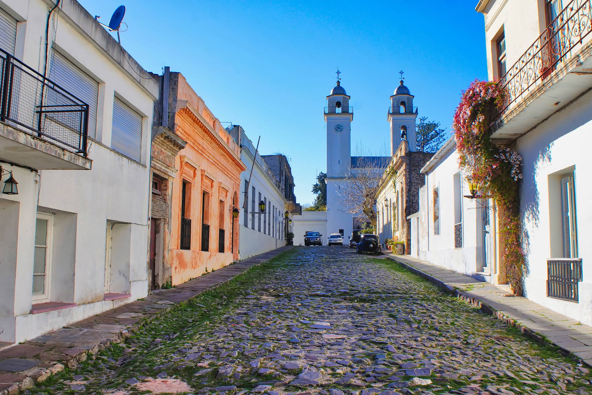 Ulica w Colonia del Sacramento z brukowaną nawierzchnią i budynkami po bokach.