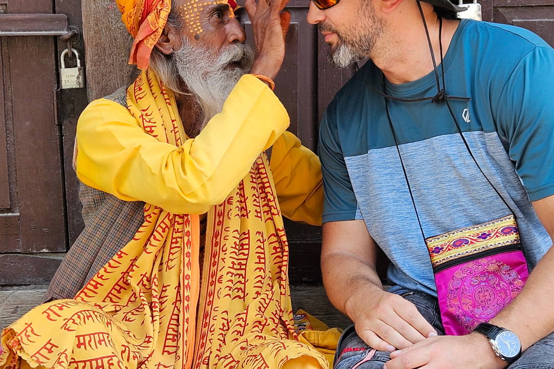 Mężczyzna w kapeluszu rozmawia z nepalskim sadhu.