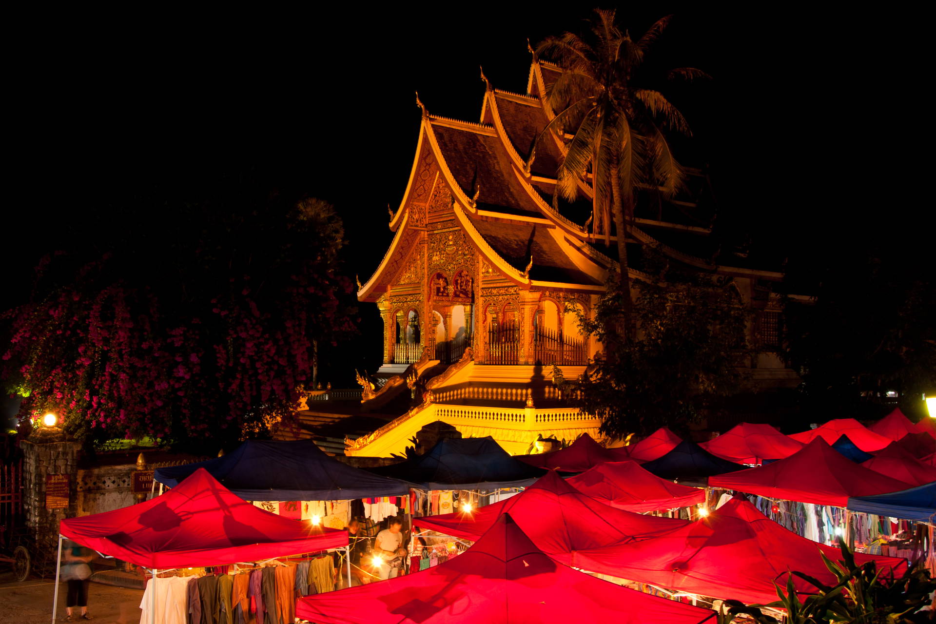 Nocna scena w Wat Xieng Thong w Luang Prabang z czerwonymi straganami.