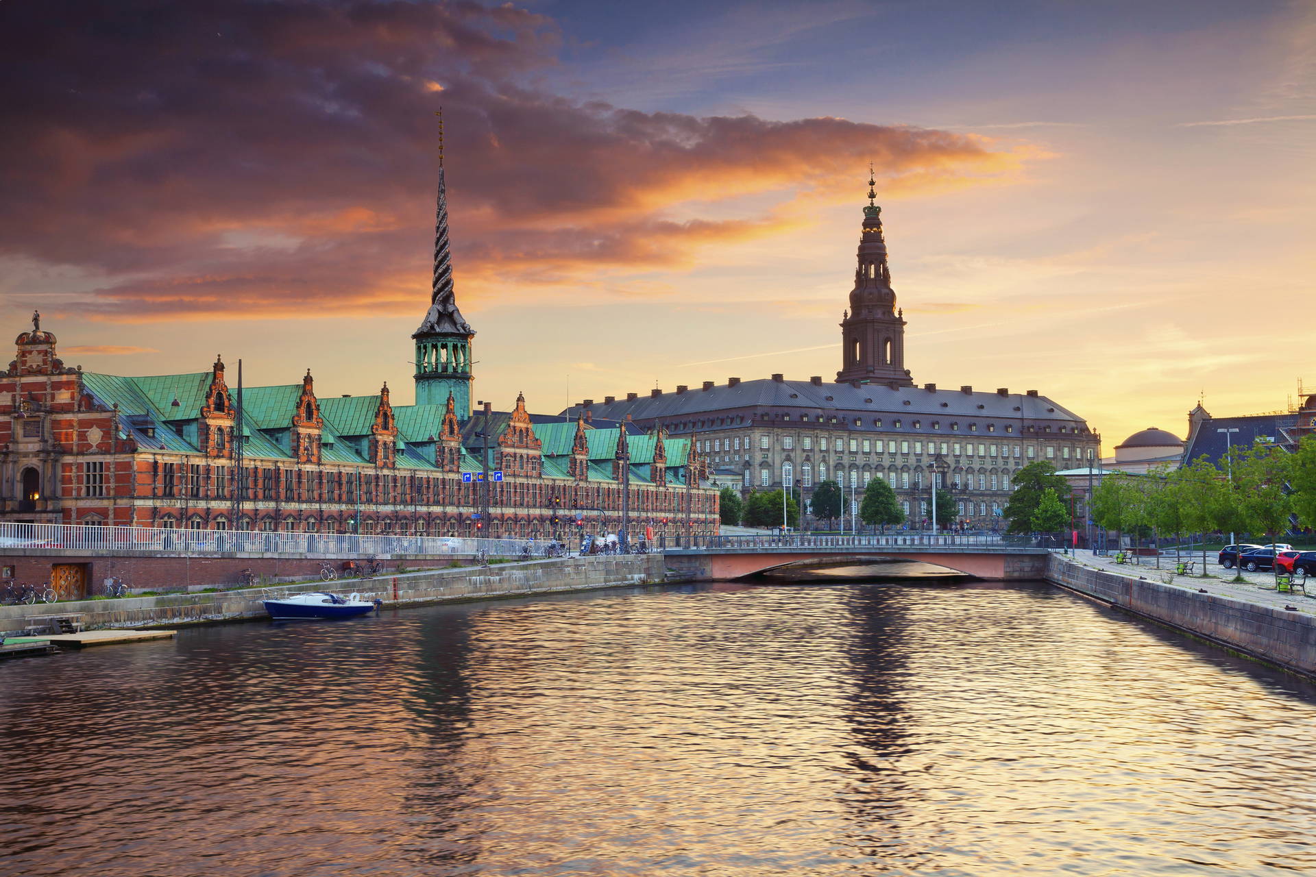 Architektura Kopenhagi nad kanałem o zachodzie słońca. Widoczny budynek Giełdy Papierów Wartościowych i Pałac Christiansborg.