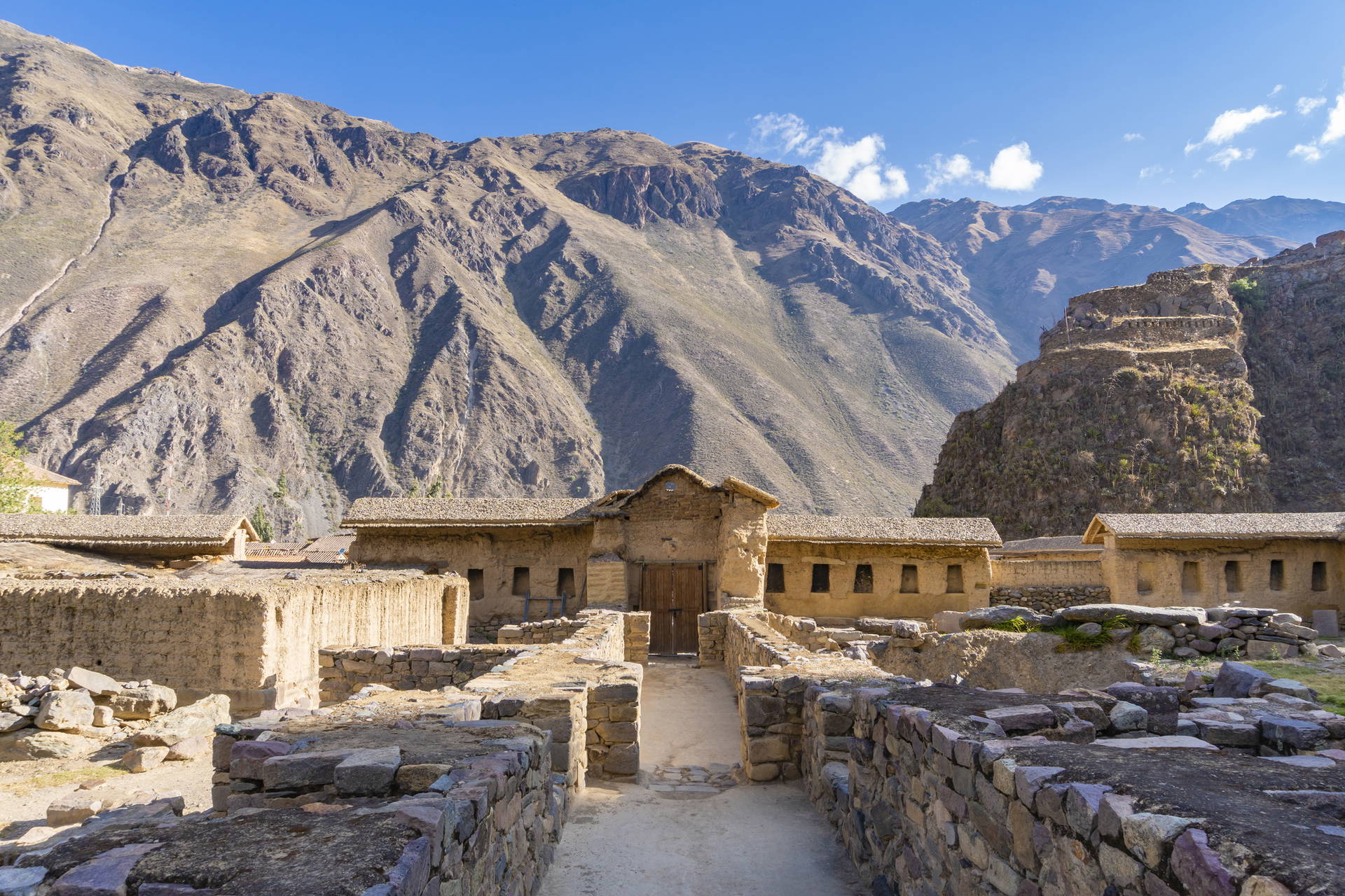 Ruiny Ollantaytambo na tle gór. Zbudowane z kamienia i gliny.