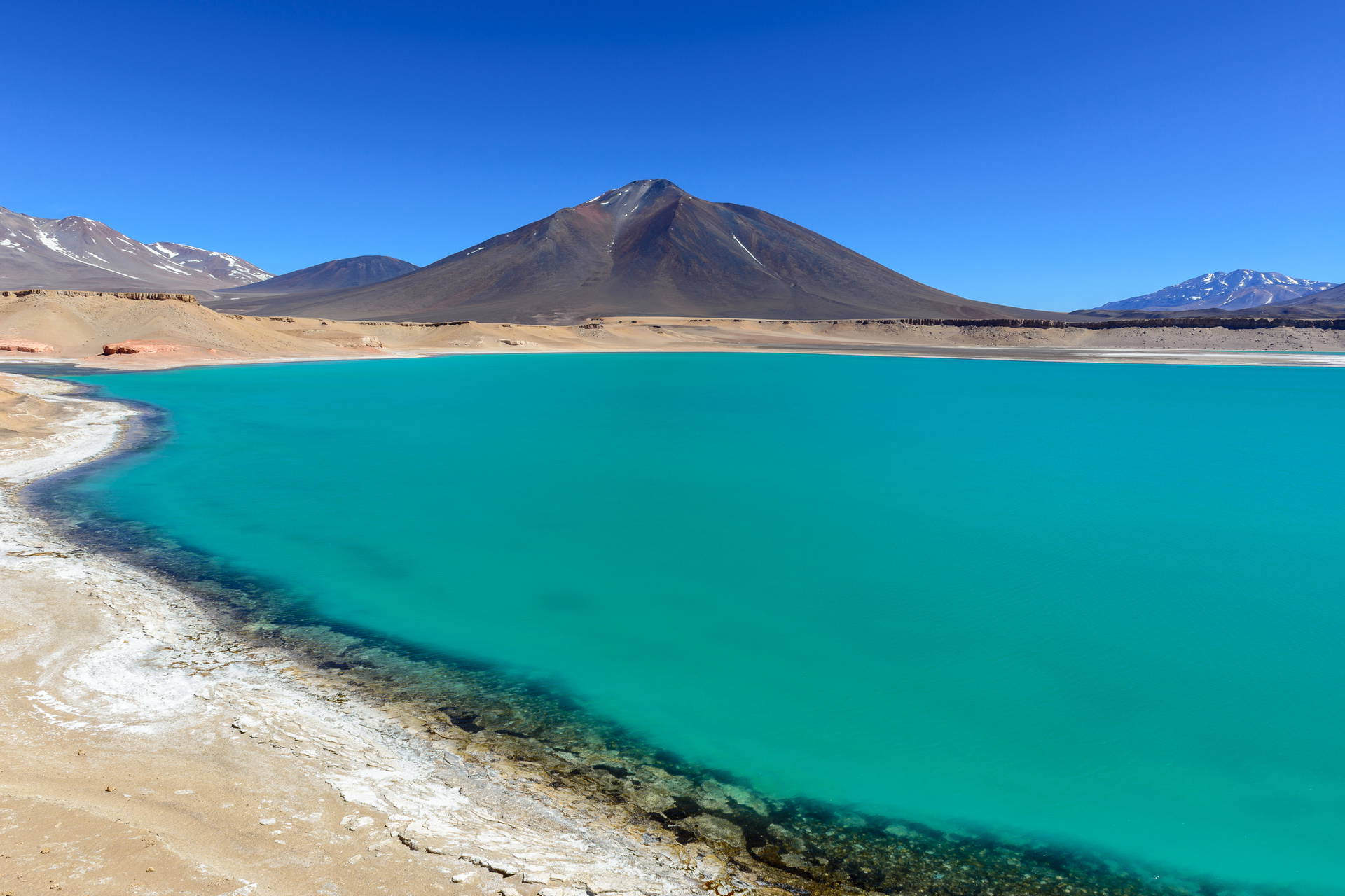 Turkusowa Laguna Miscanti w Chile z wulkanami w tle.