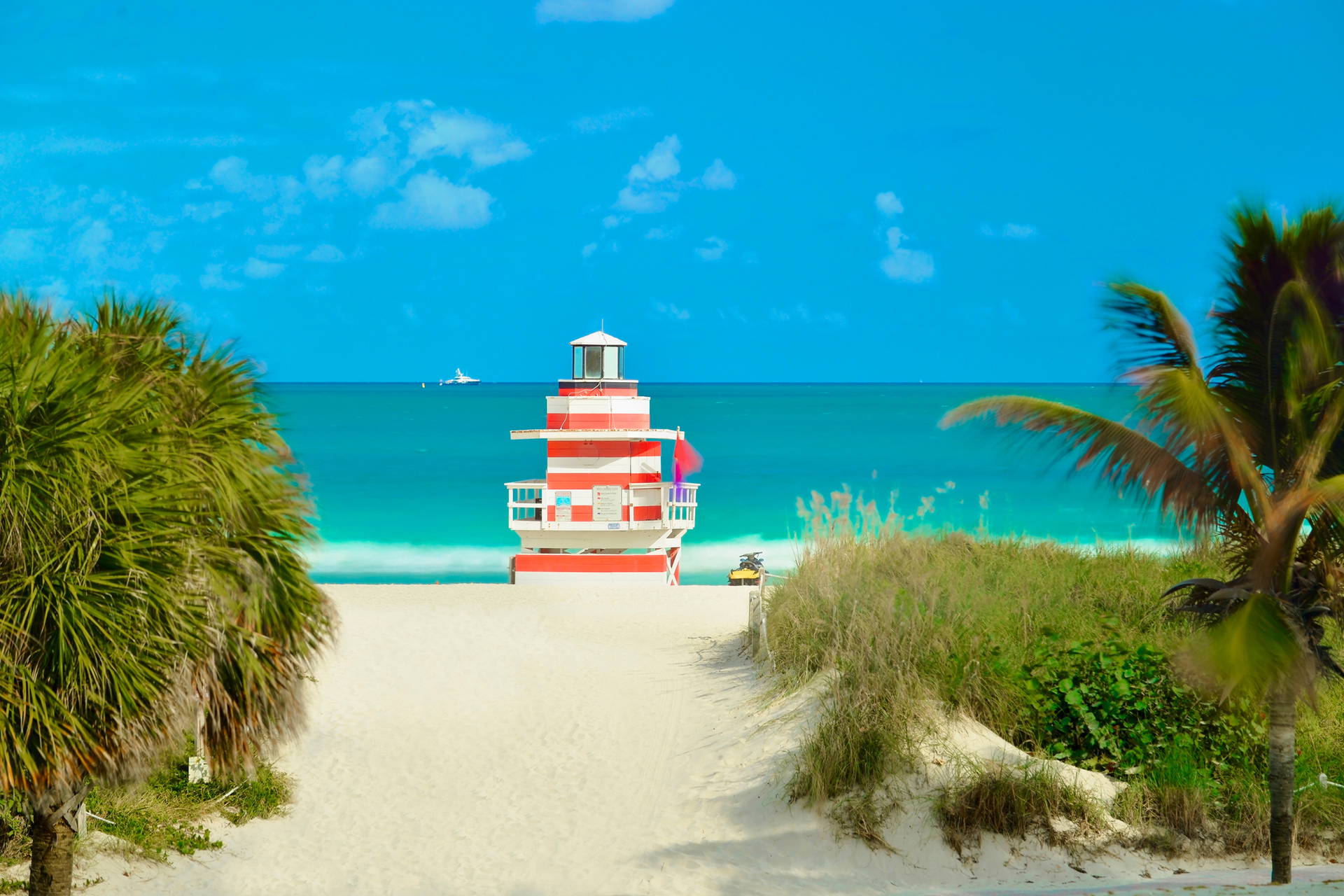 Wieża ratownicza w biało-czerwone pasy na tle plaży i turkusowego oceanu w Miami Beach.