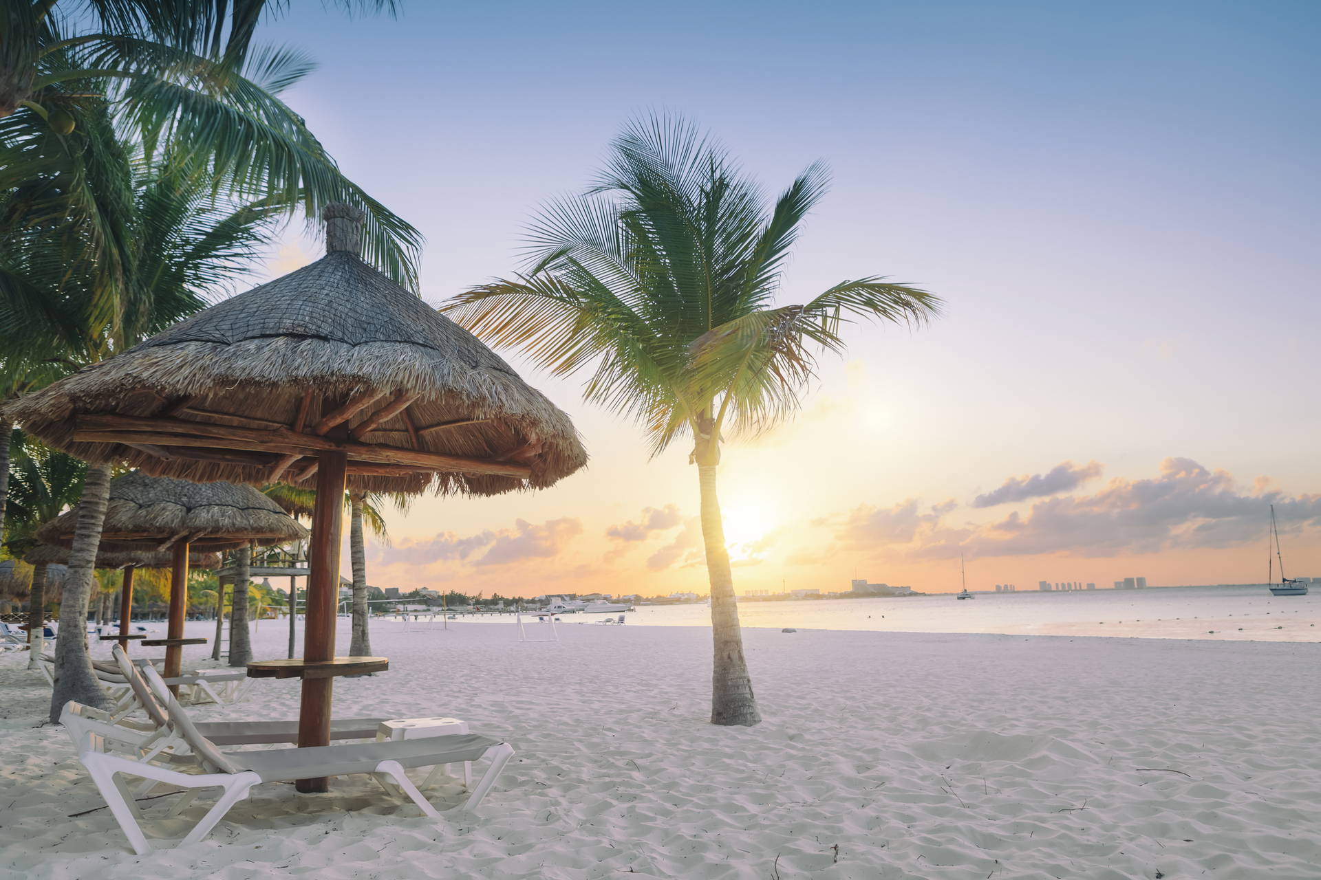 Plaża w Cancun z palmami i parasolami.