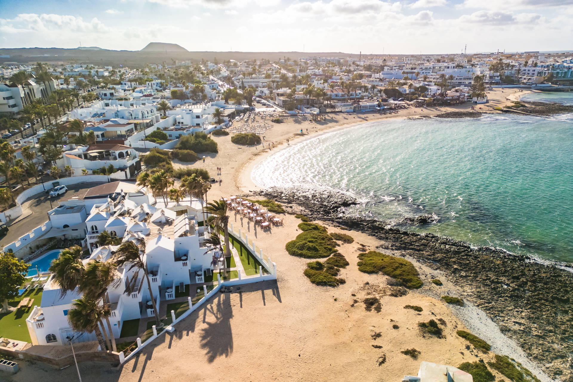 Widok z lotu ptaka na Corralejo na Fuerteventurze. Białe domy, piaszczysta plaża i turkusowy ocean.