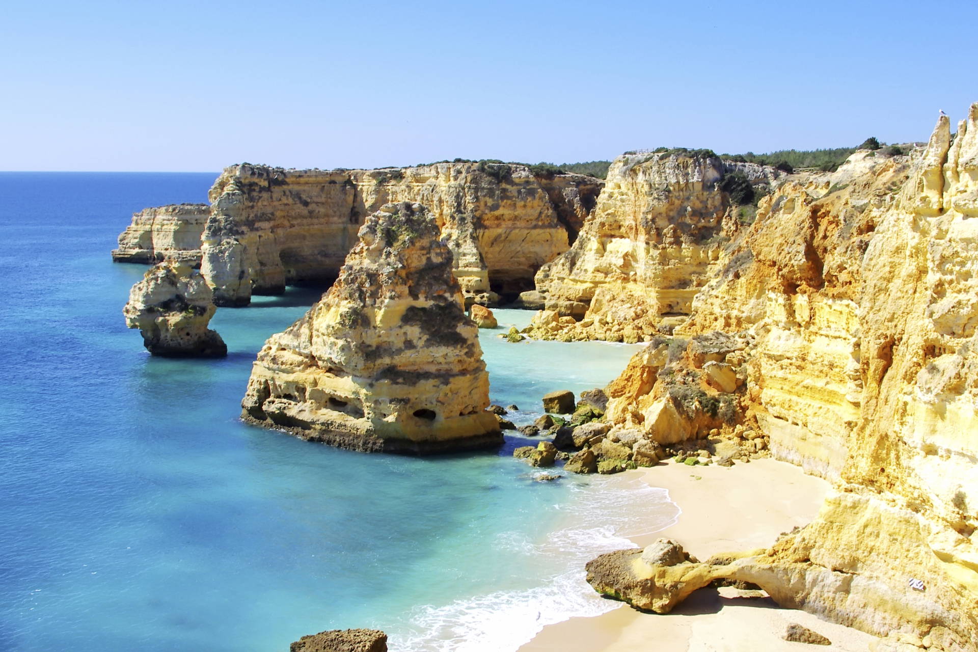 Plaża Praia da Marinha w Portugalii widziana z góry. Widać formacje skalne i błękitną wodę.