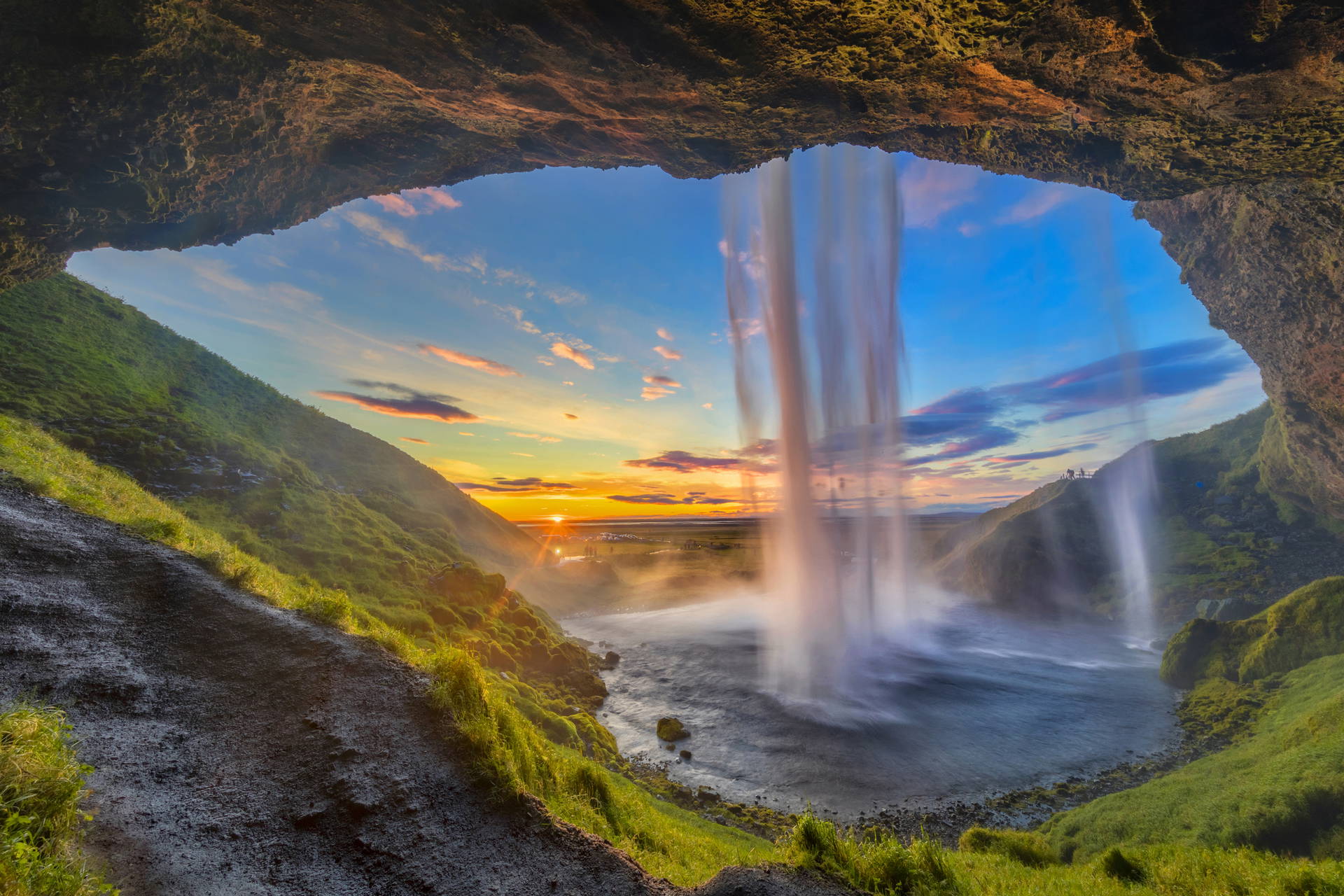Wnętrze jaskini z wodospadem Seljalandsfoss w Islandii o zachodzie słońca.
