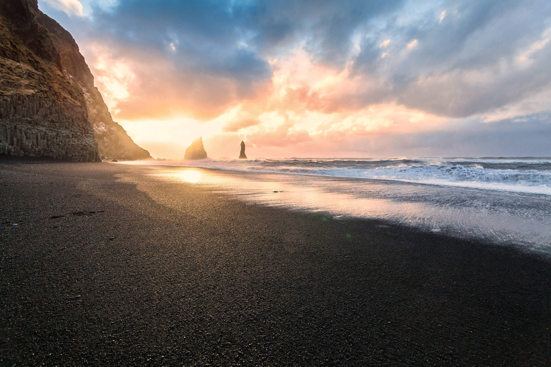Czarna plaża w Vik i bazaltowe klify Reynisdrangar w Islandii o zachodzie słońca.