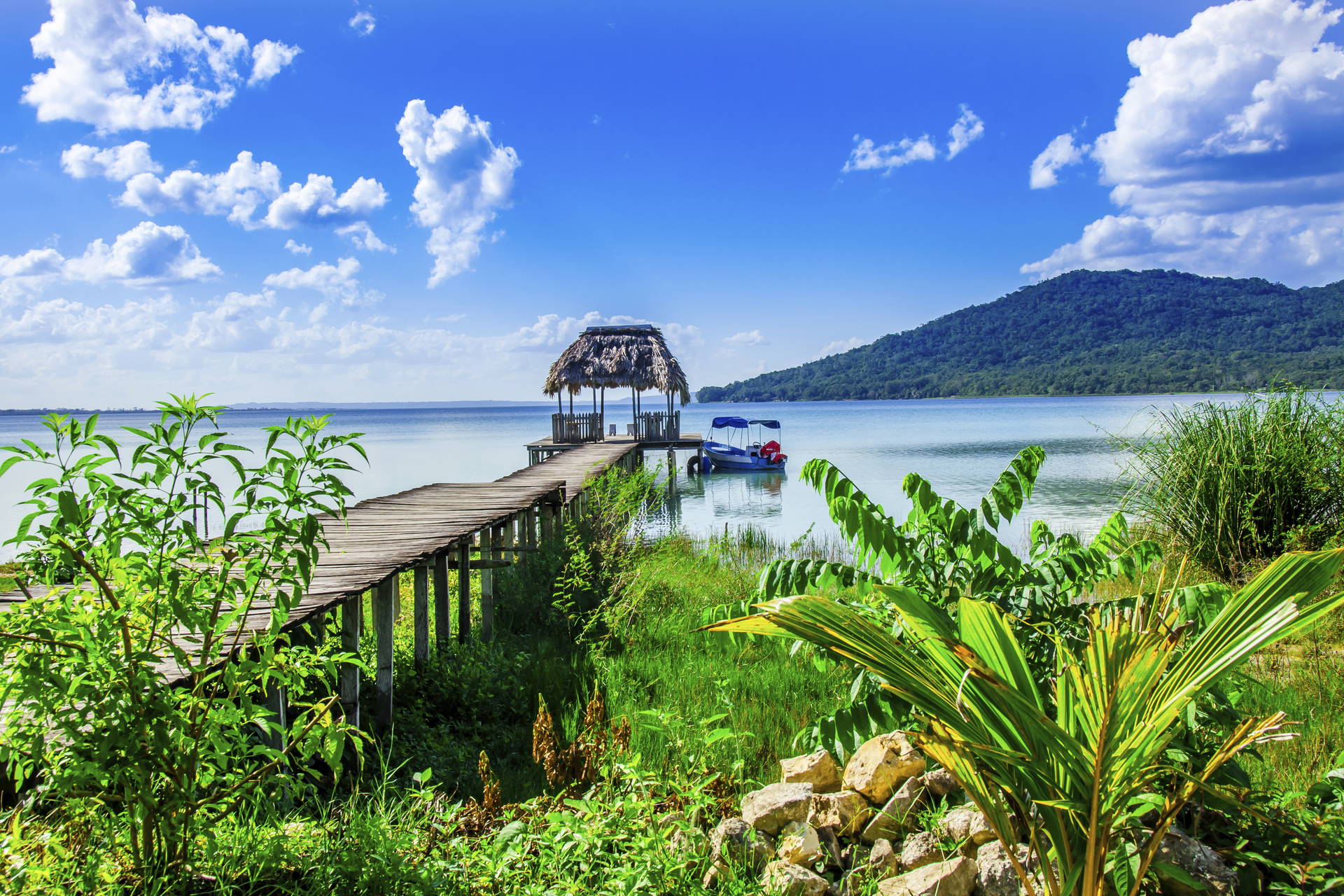 Pomost z altaną i łódką na jeziorze Izabal w Gwatemali.