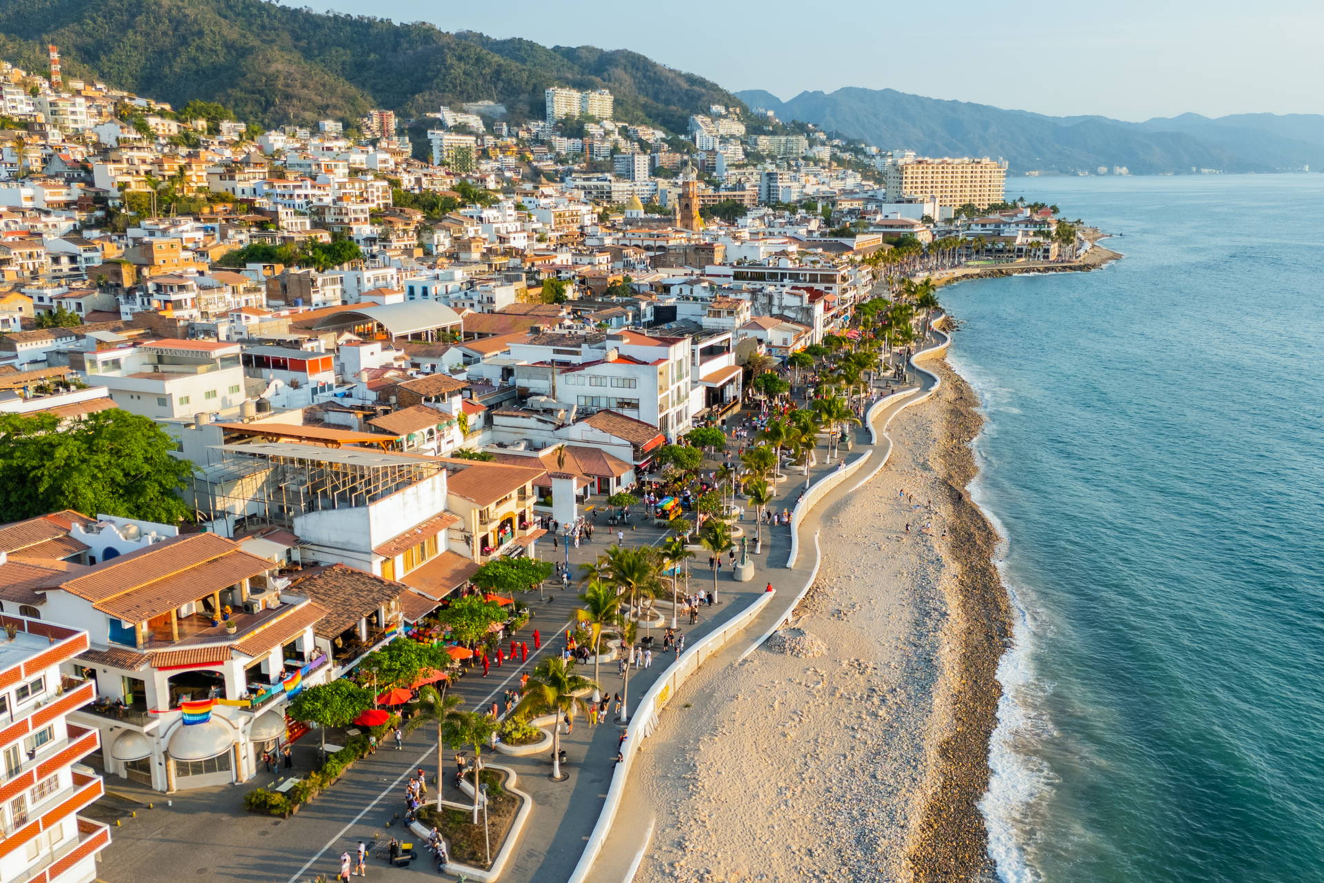 Panorama Puerto Vallarta w Meksyku: miasto położone na wzgórzu, nadmorska promenada i ocean.