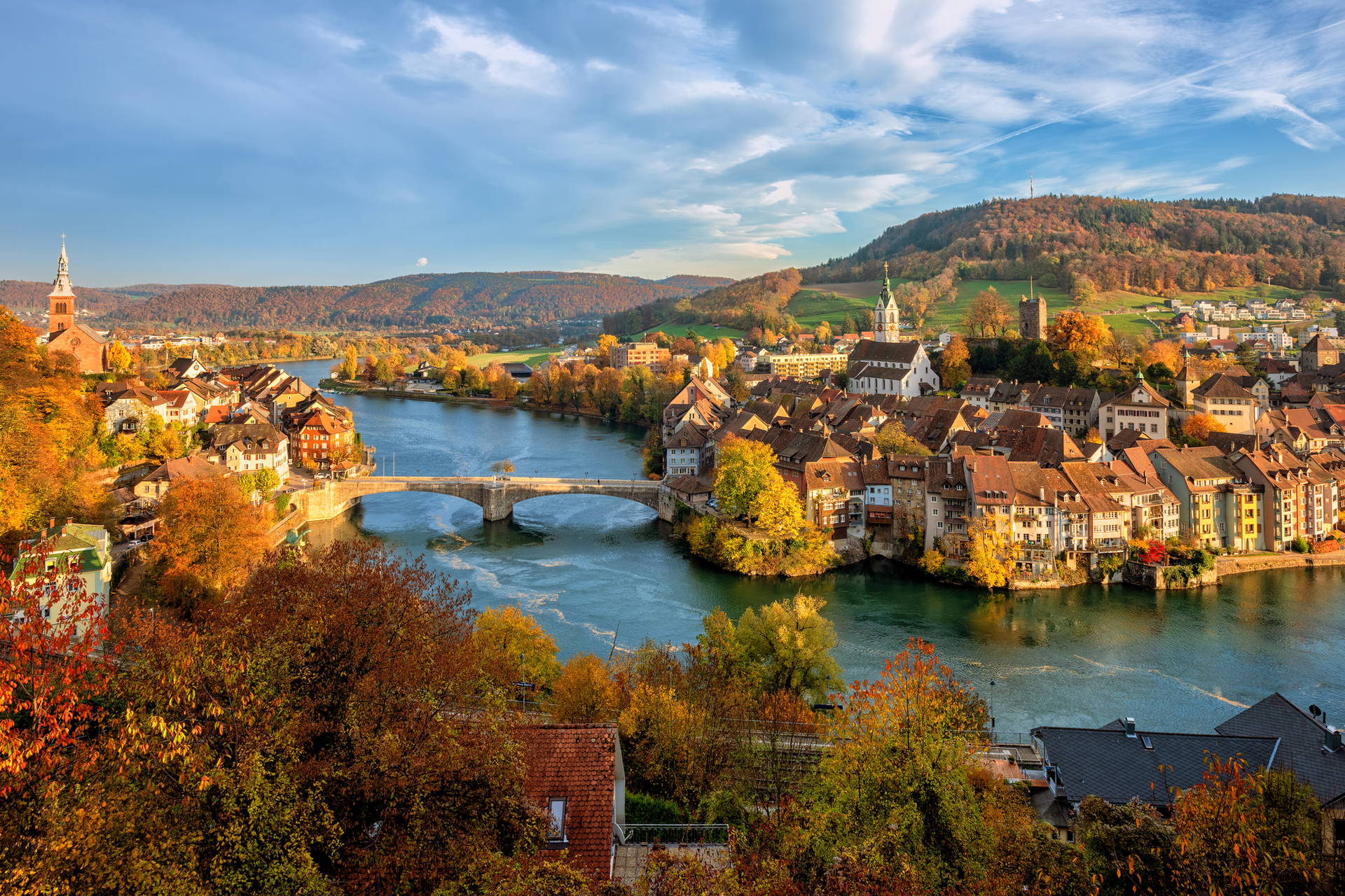 Jesienny widok na Stein am Rhein w Szwajcarii: rzeka, miasto i wzgórza.