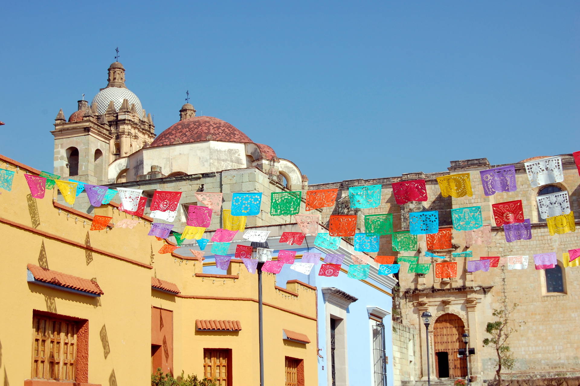 Kolorowe flagi powiewają nad ulicą w Oaxaca, Meksyk.