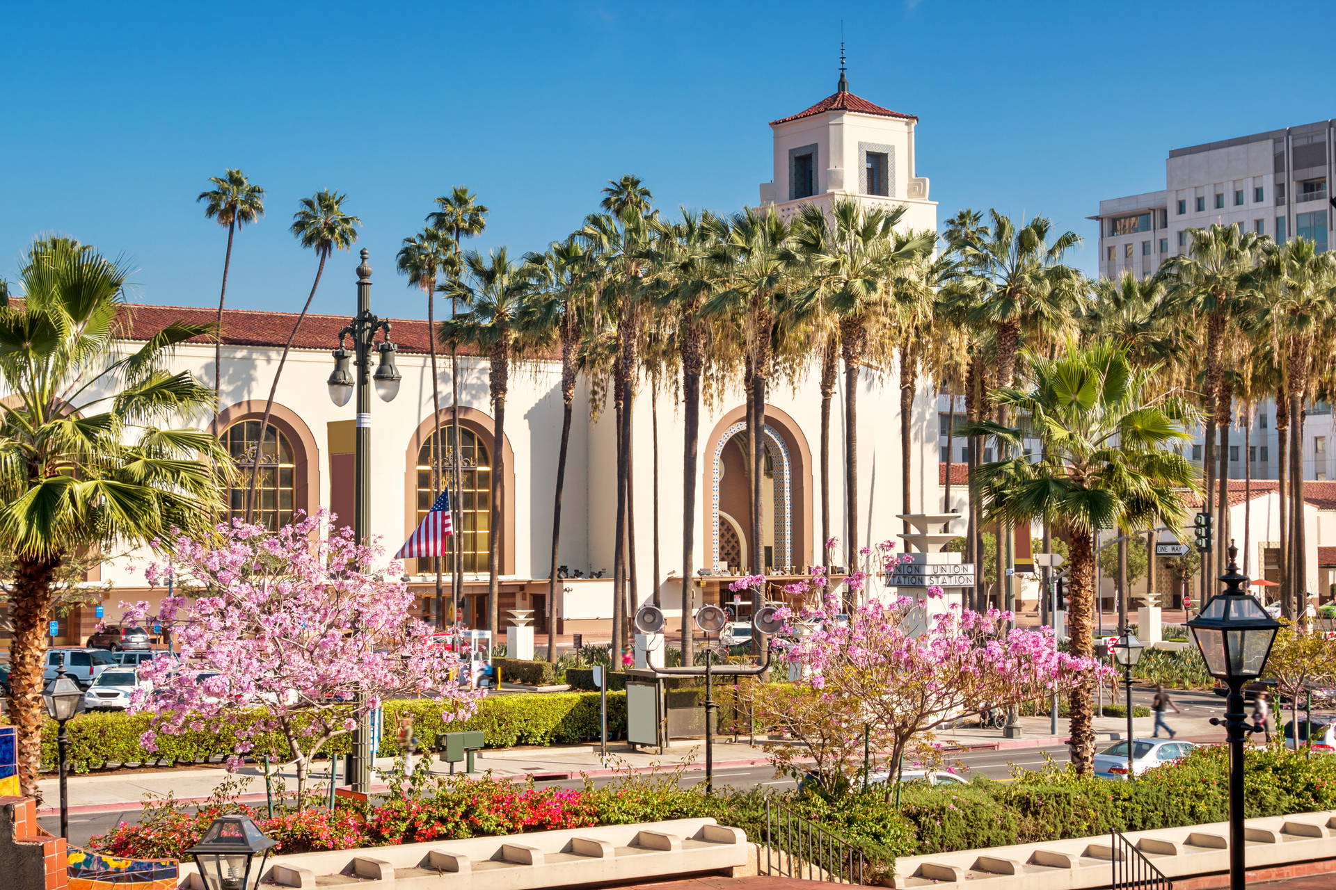 Union Station w Los Angeles otoczona palmami i kwitnącymi drzewami.