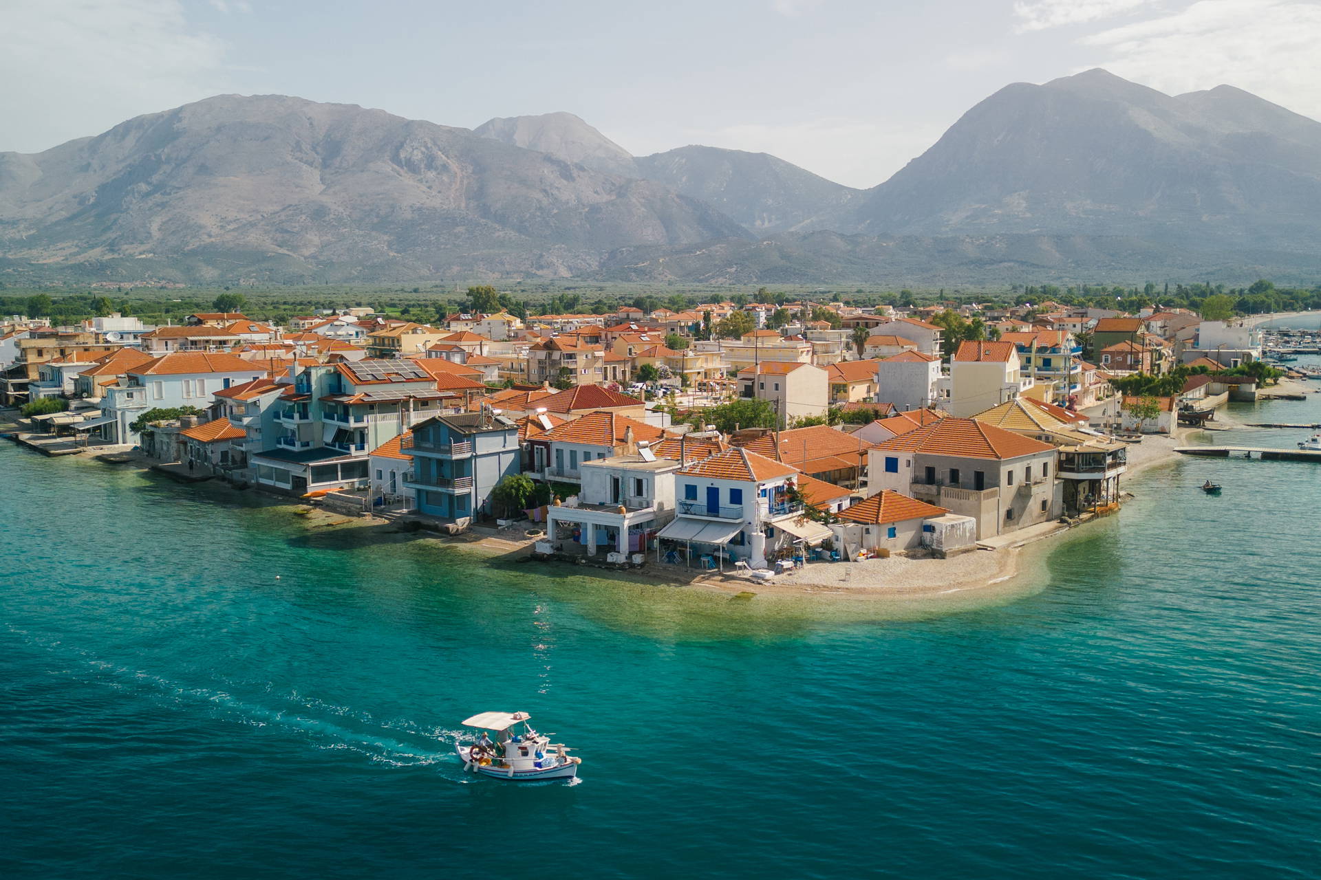 
Widok z lotu ptaka na Kokkari na Samos – miasteczko na półwyspie, otoczone turkusowym morzem i górami w tle.