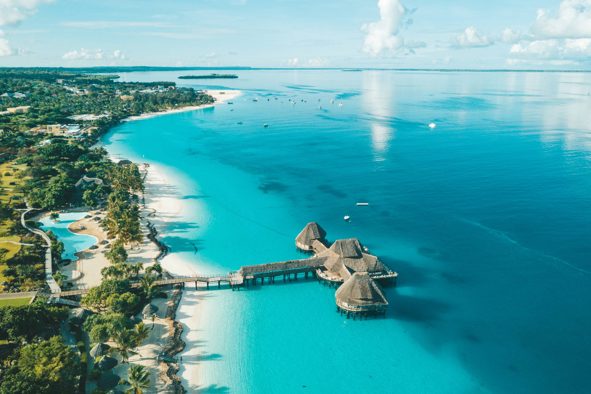 Plaża na Zanzibarze z lotu ptaka. Widoczne domki na wodzie i turkusowa woda.