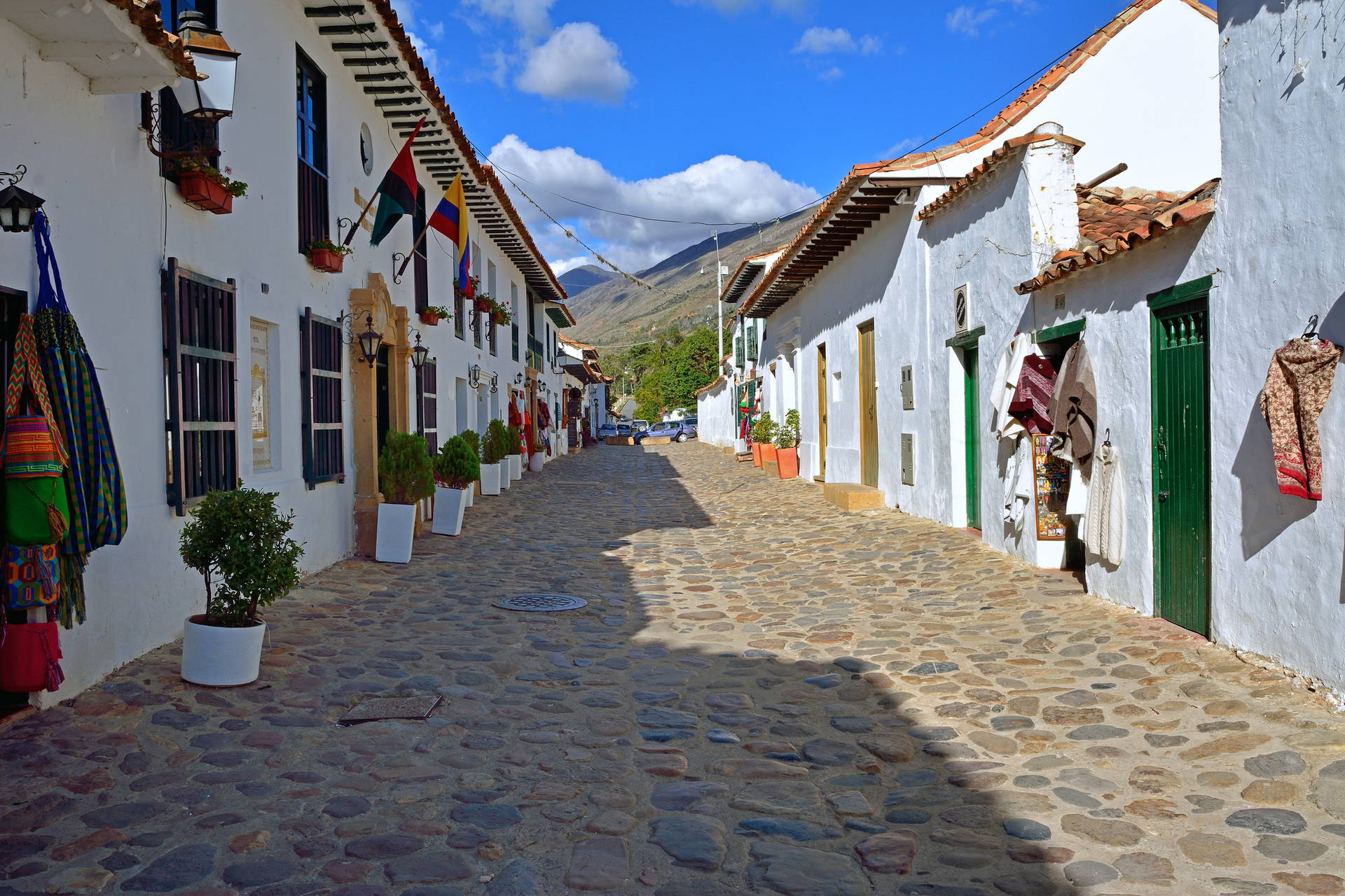 Ulica w Villa de Leyva, Kolumbia: brukowana droga i białe budynki.