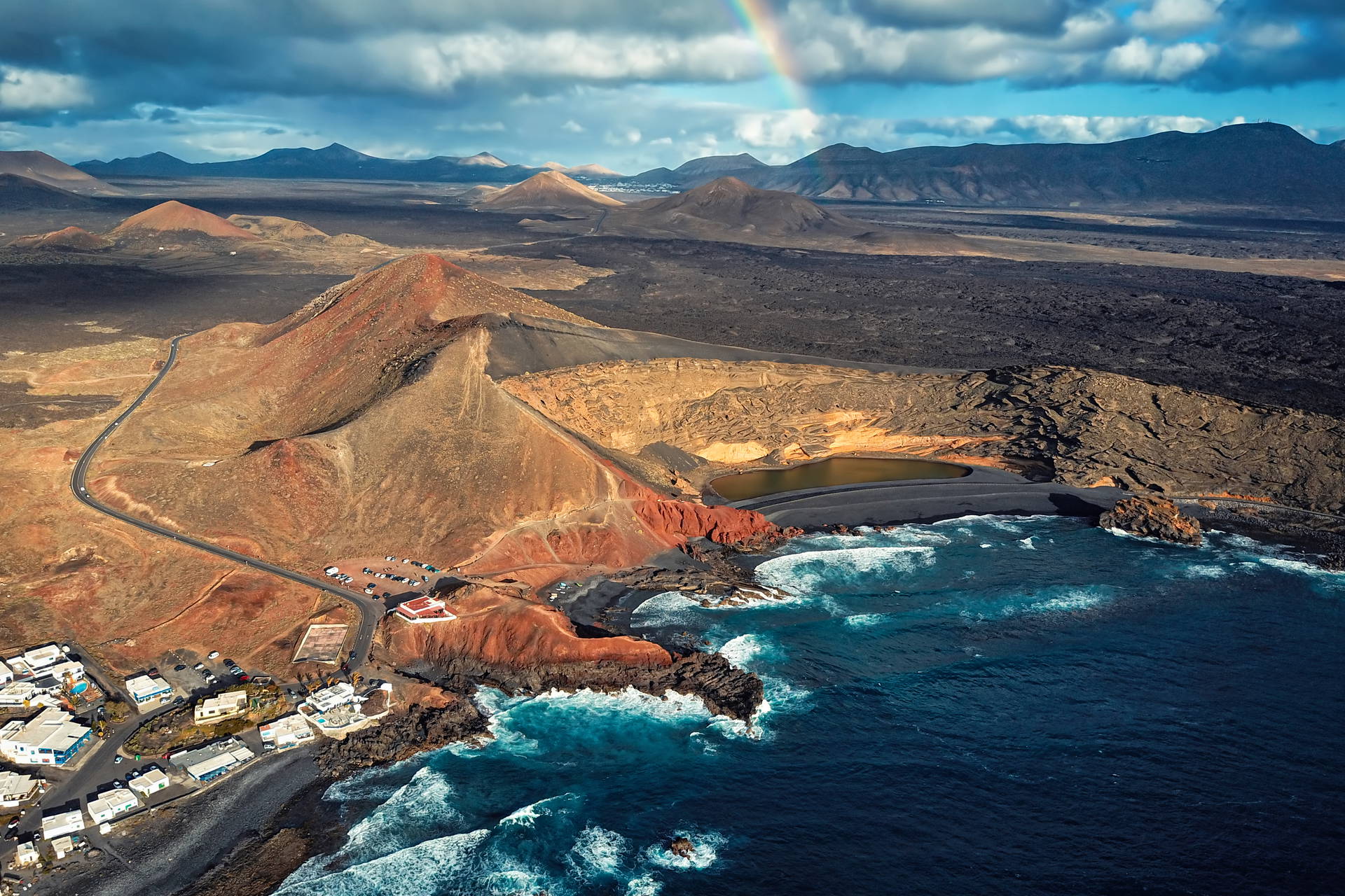 El Golfo na Lanzarote z lotu ptaka. Wulkaniczny krajobraz z zielonym jeziorem, czarną plażą i tęczą.