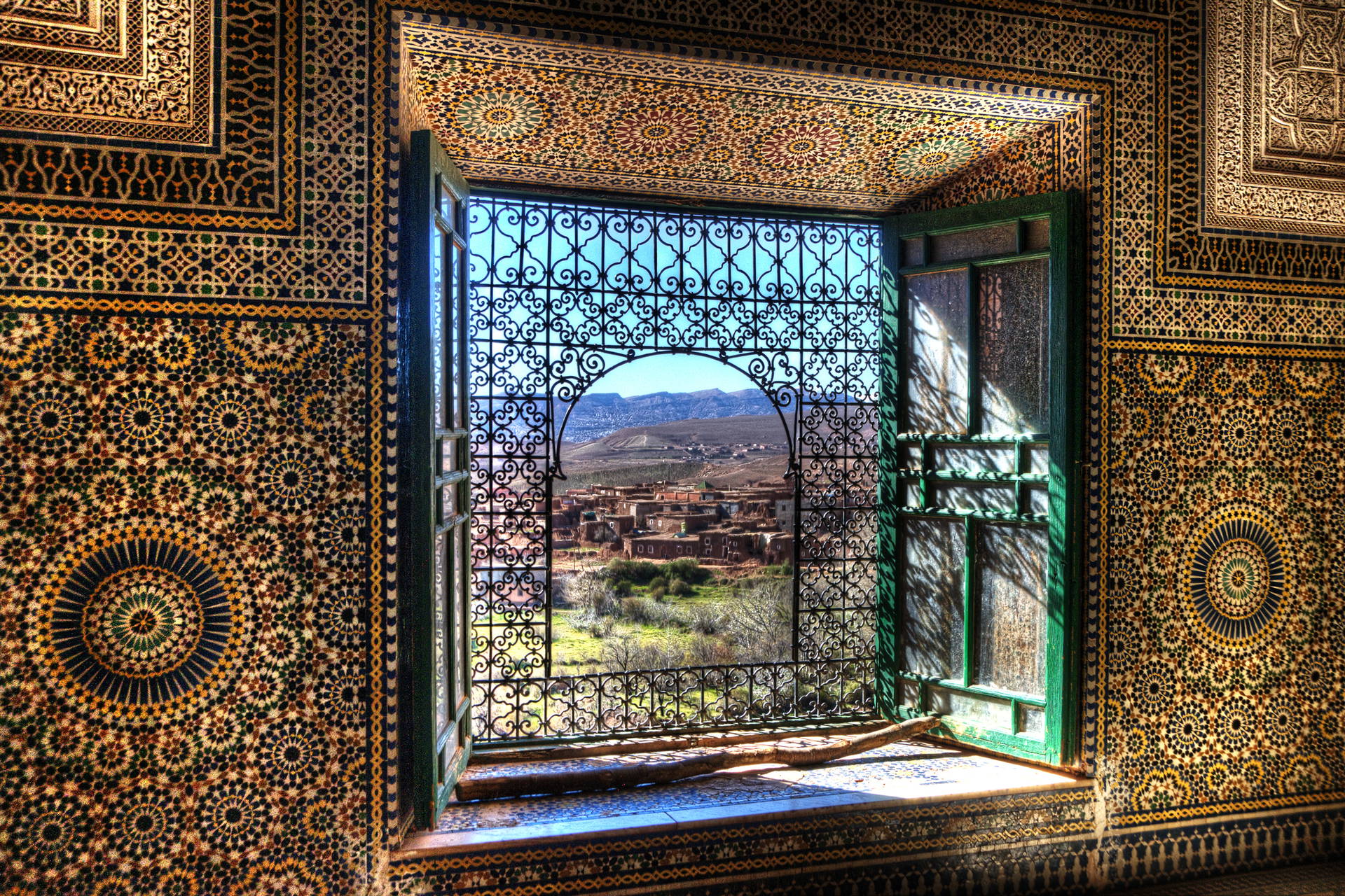 Wnętrze z oknem z widokiem na marokański krajobraz.