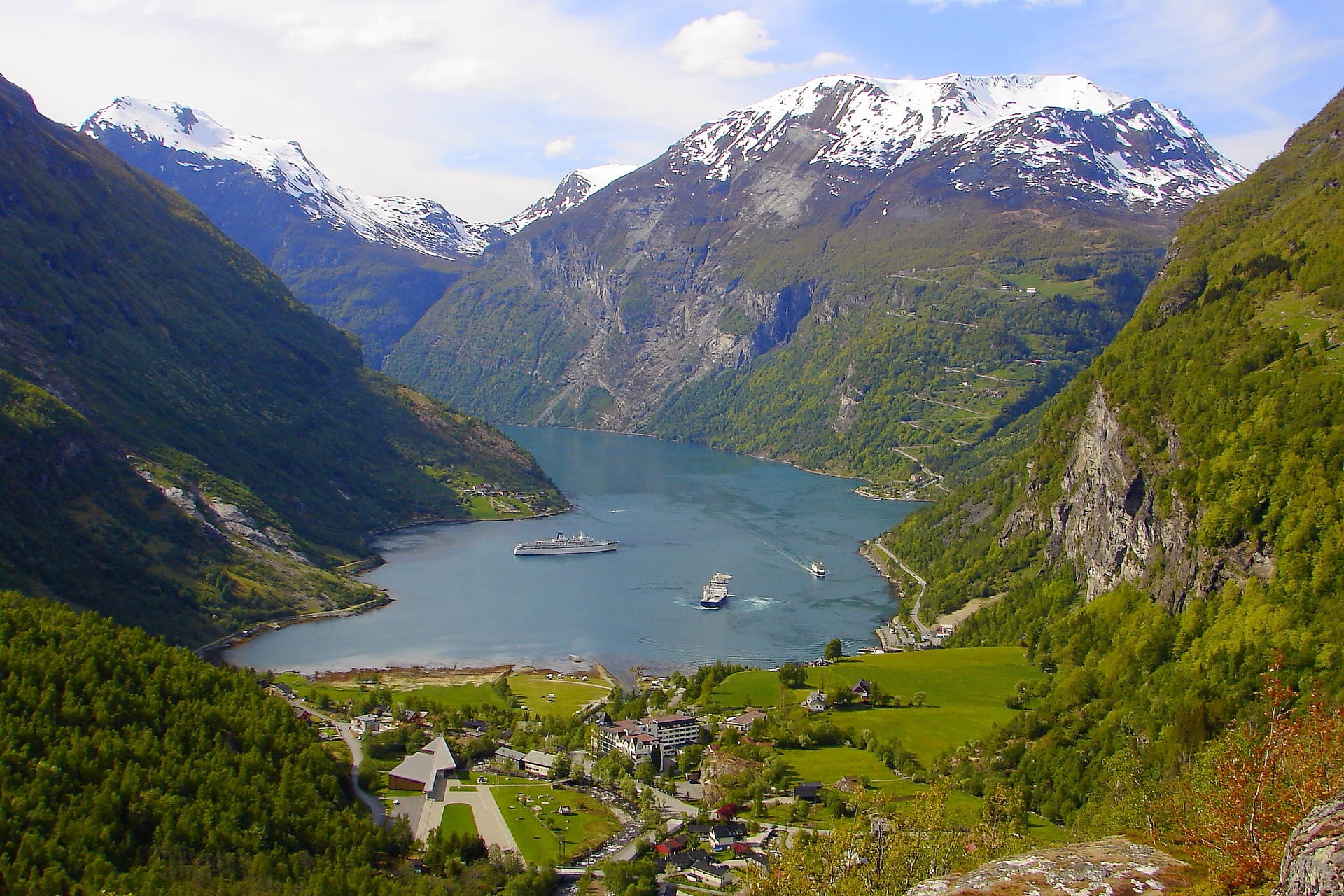 Geirangerfjord w Norwegii: widok z góry na fiord, ośnieżone góry i statki.