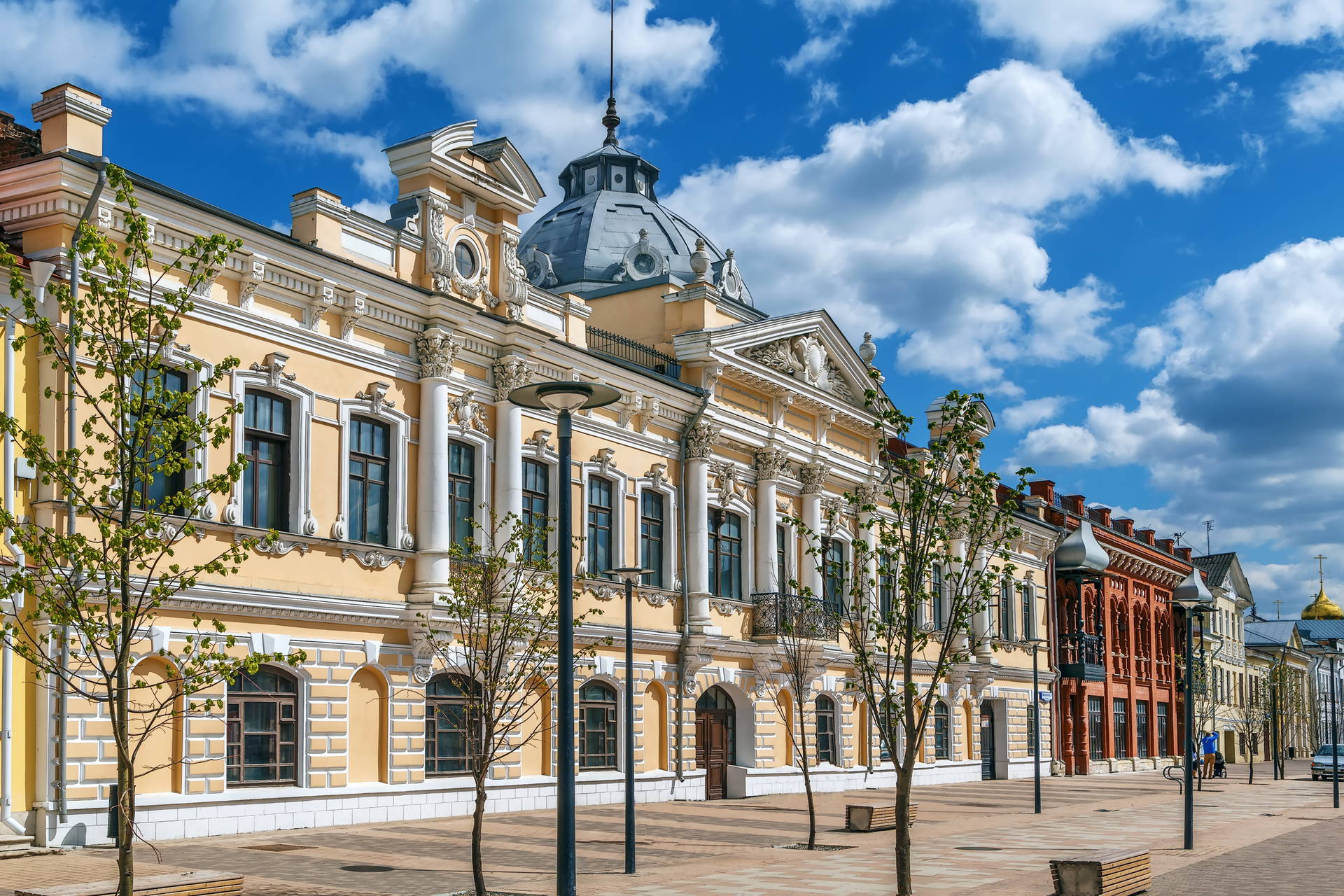 Żółty budynek z kolumnami i kopułą, bogato zdobiony.