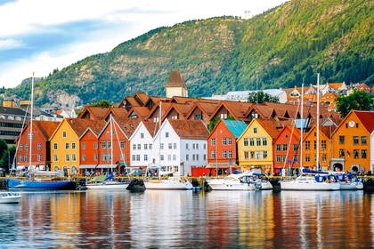 Kolorowe budynki Bryggen w Bergen odbite w wodzie.