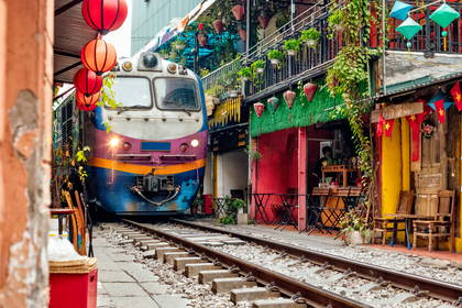 Pociąg przejeżdża przez wąską uliczkę w Hanoi, Wietnam.