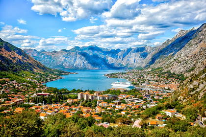 Widok na Kotor w Czarnogórze: zatoka, góry i statek.