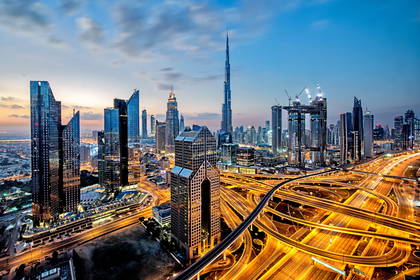 Panorama Dubaju o zmierzchu z widocznymi wieżowcami, w tym Burdż Chalifa.