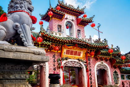 Fasada świątyni Fujian w Hoi An z lampionami i posągiem lwa.