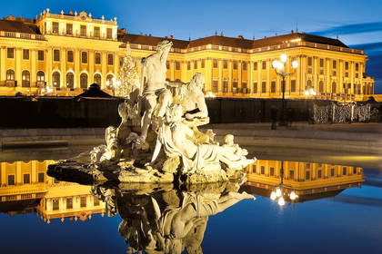 Fontanna Neptuna w nocy na tle pałacu Schönbrunn w Wiedniu.