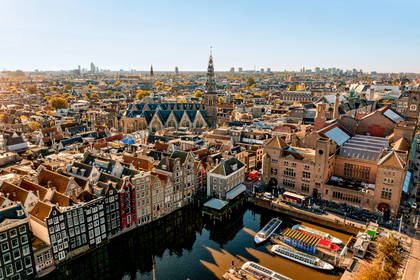 Panorama Amsterdamu z rzeką i zabytkowymi budynkami.