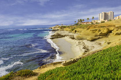 Plaża La Jolla w San Diego: klify, piasek i budynek w tle.